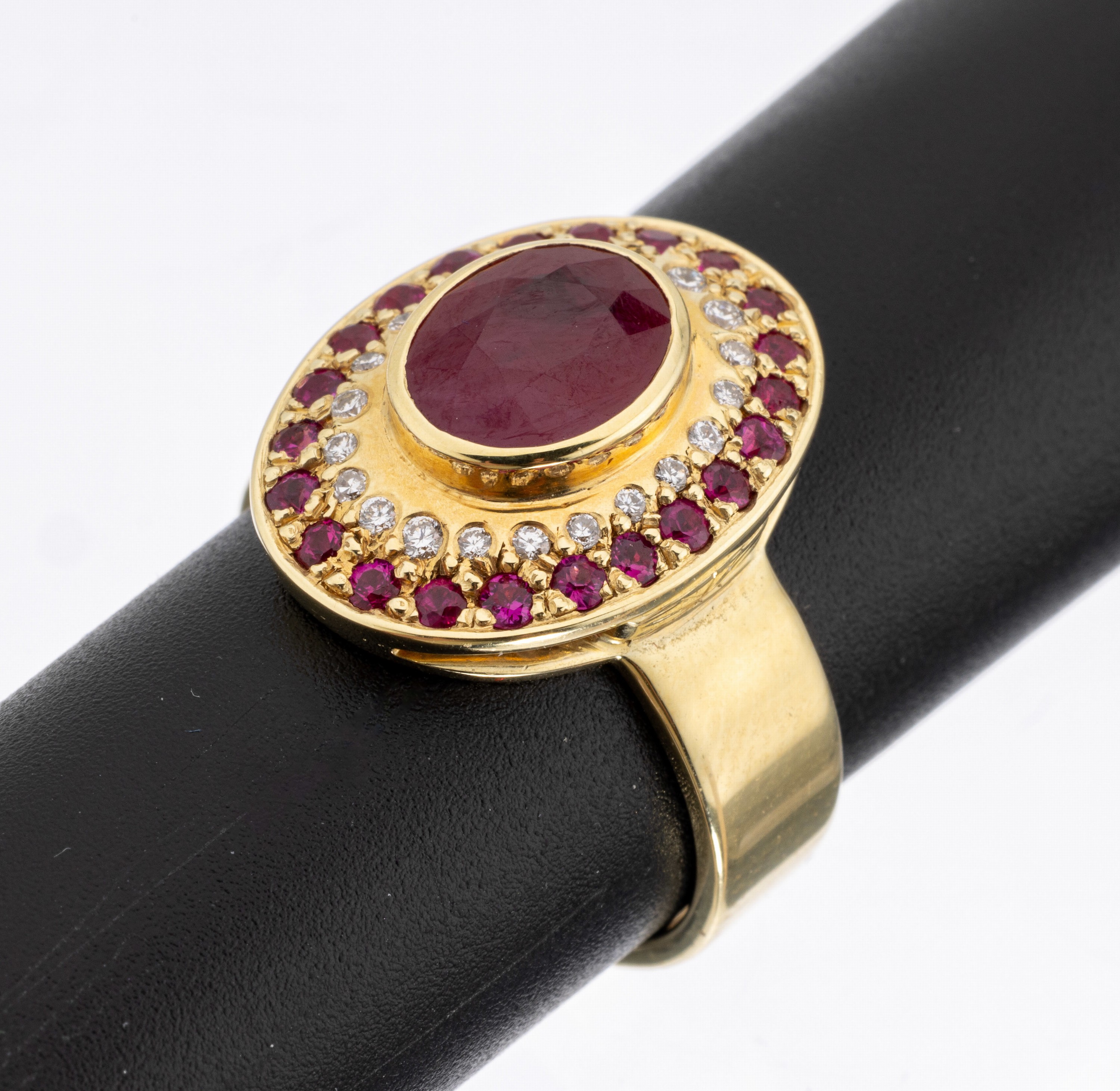 14 kt Gold Rubin-Brillant-Ring, GG 585/000,ovalfacett. Rubin (beh.) ca. 2.98 ct (besch.),22 rundfacett. Rubine zus. ca. 0.70 ct, 21 Brillanten zus. ...