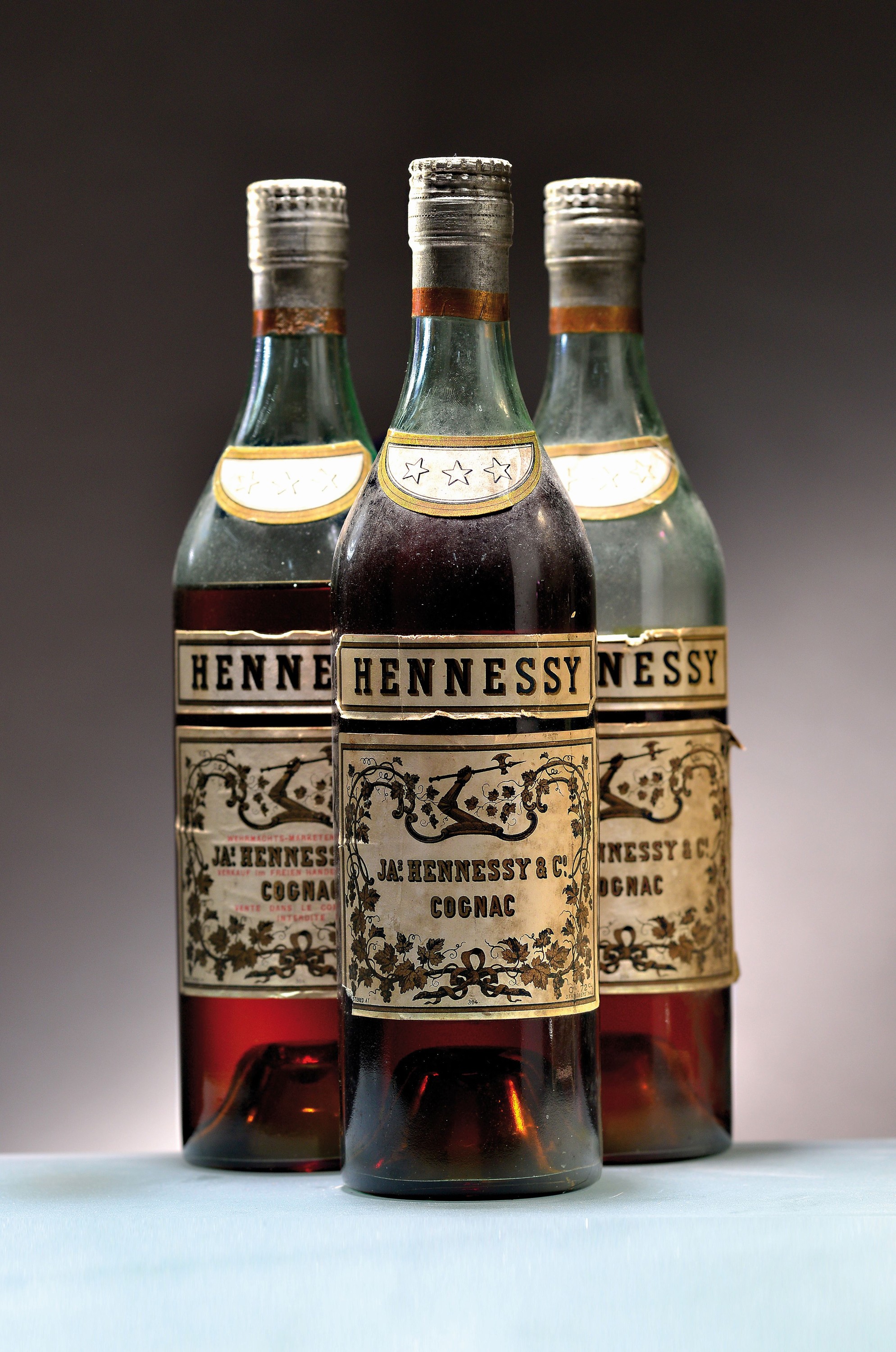 3 Flaschen Hennessy & Co. 3 Star Cognac, um 1937-1944, 1x Wehrmachts-Marketenderware, Below Shoulder, verso Etikett lädiert; 1x ca. upper mid ...