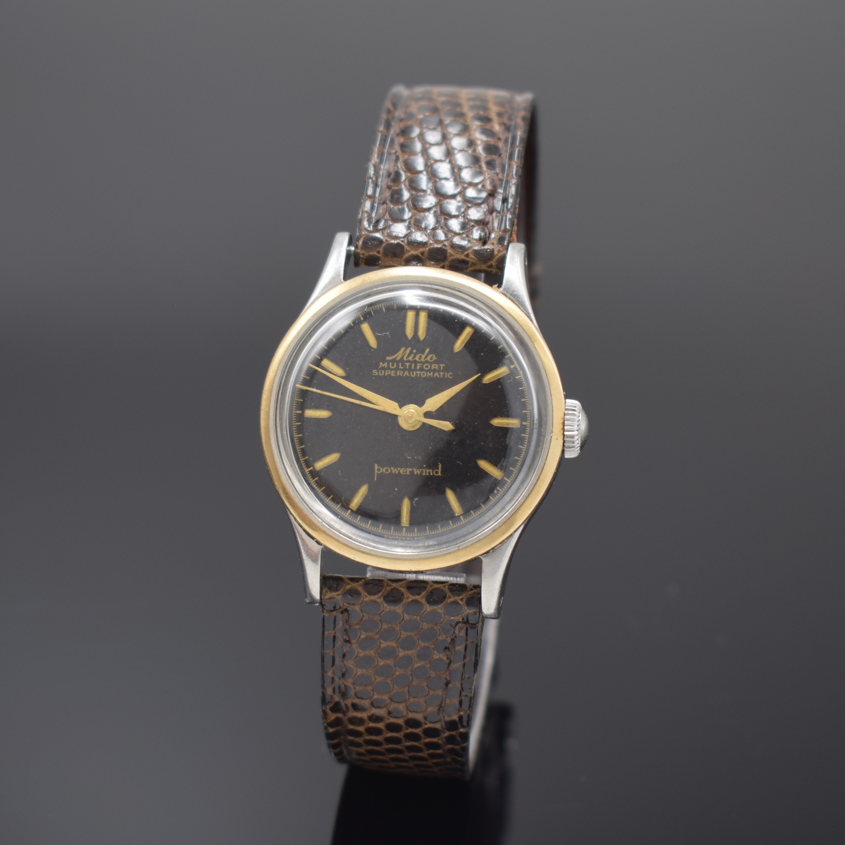 MIDO Multifort Powerwind Herrenarmbanduhr, Schweiz um 1958, Edelstahlgeh., Boden verschr., Goldlünette aufgedr., schwarzes Zifferblatt altersbed. ...