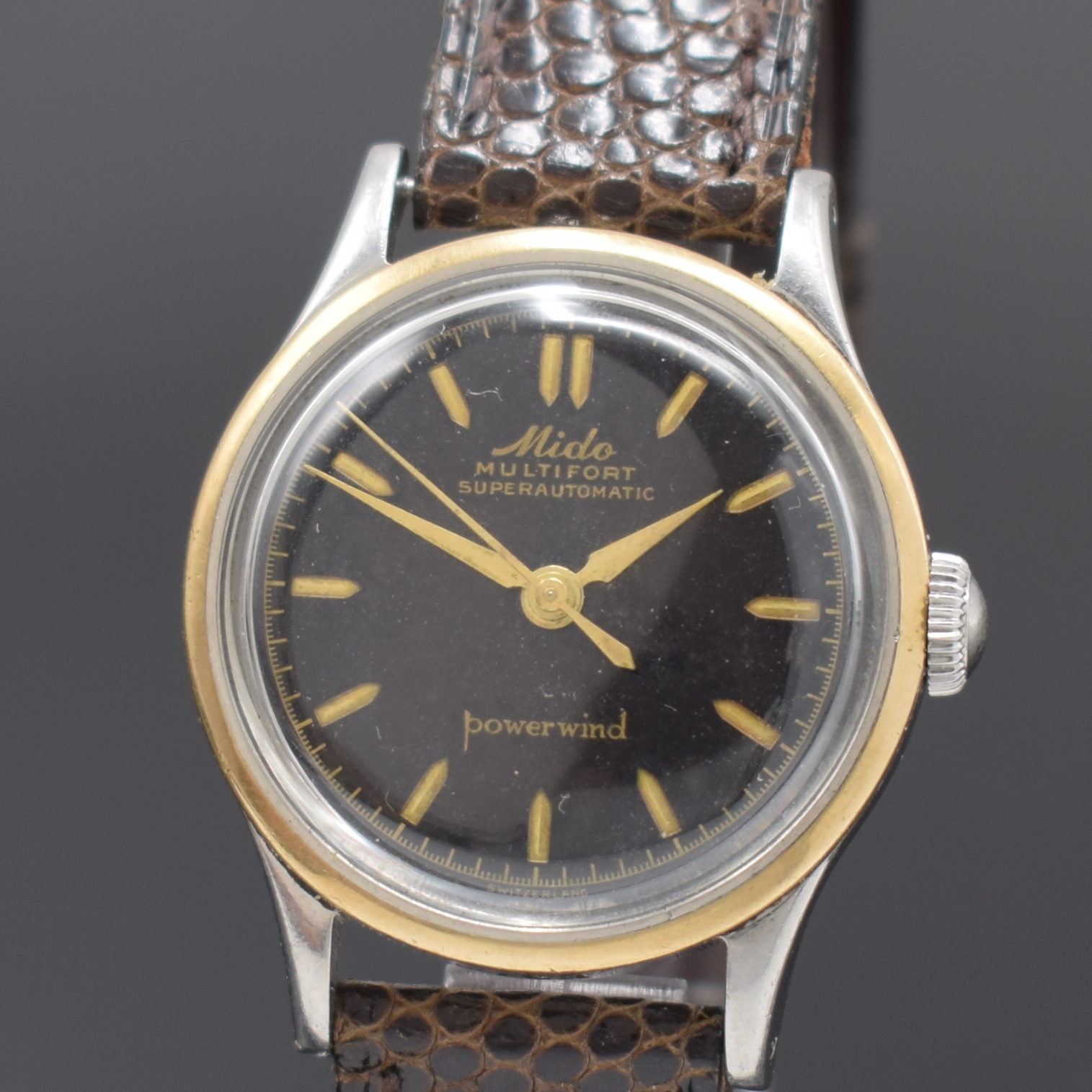 Detail a: MIDO Multifort Powerwind Herrenarmbanduhr, Schweiz um 1958, Edelstahlgeh., Boden verschr., Goldlünette aufgedr., schwarzes Zifferblatt altersbed. ...