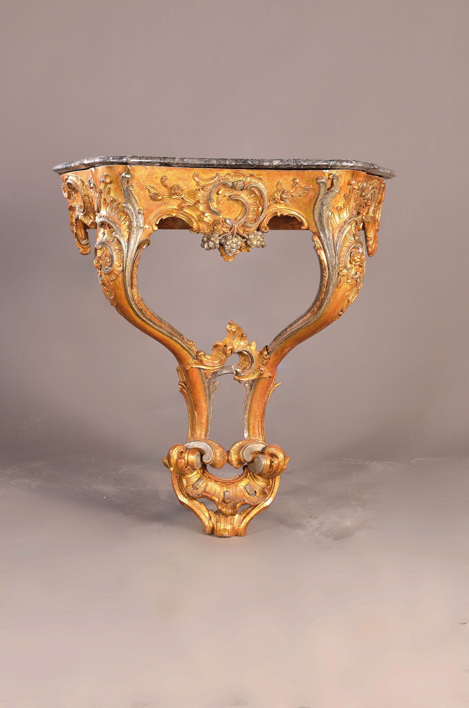 Wandkonsole, Rokoko, um 1750, Holz geschnitzt, golden und silberfarben gefaßt, Dekor mit Trauben, Blumen und Rocaillen, graue Marmorplatte ...