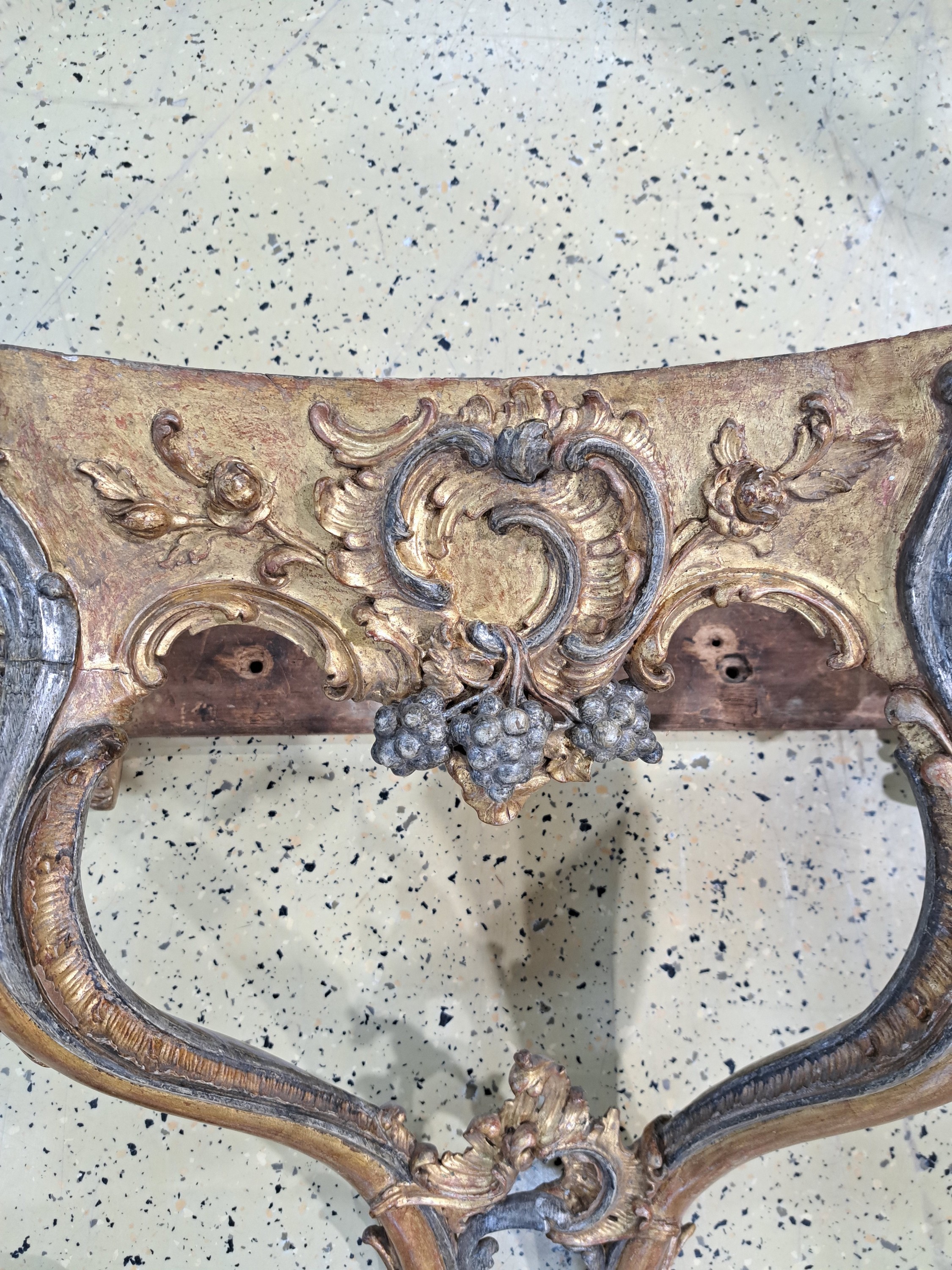 Detail b: Wandkonsole, Rokoko, um 1750, Holz geschnitzt, golden und silberfarben gefaßt, Dekor mit Trauben, Blumen und Rocaillen, graue Marmorplatte ...