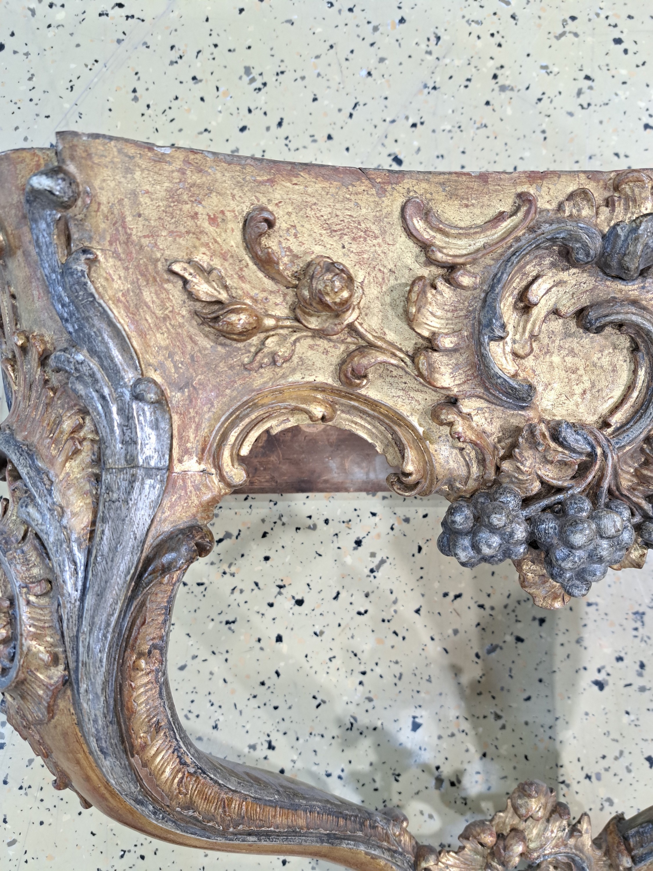 Detail h: Wandkonsole, Rokoko, um 1750, Holz geschnitzt, golden und silberfarben gefaßt, Dekor mit Trauben, Blumen und Rocaillen, graue Marmorplatte ...