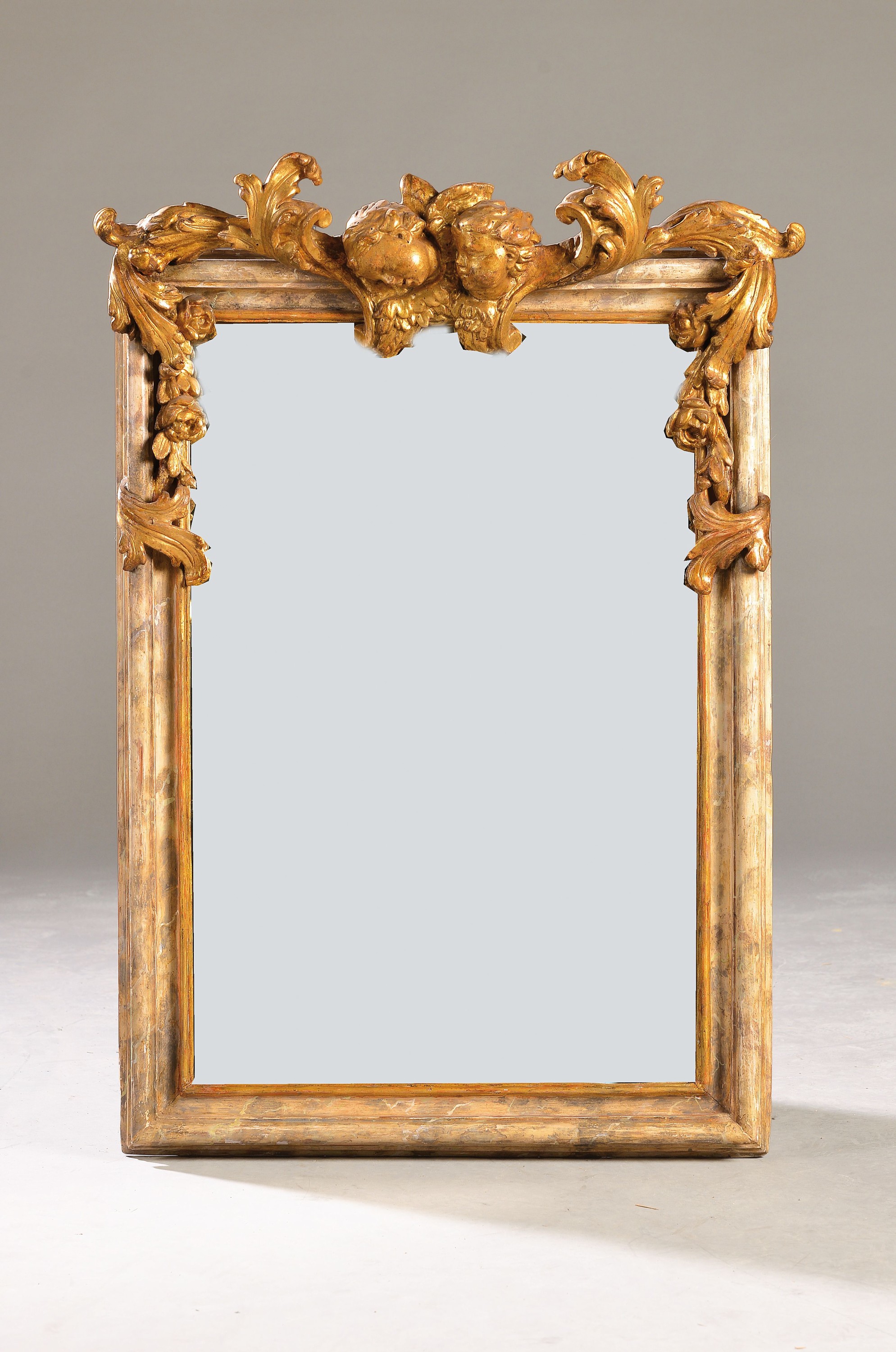 Wandspiegel, Barock, 18. Jh., Holz, profilierter Rahmen marmorierte Fassung, Bekrönung zwei Puttenköpfe geschnitzt, Glas ergänzt, ca. 87 x 63 cm, ...