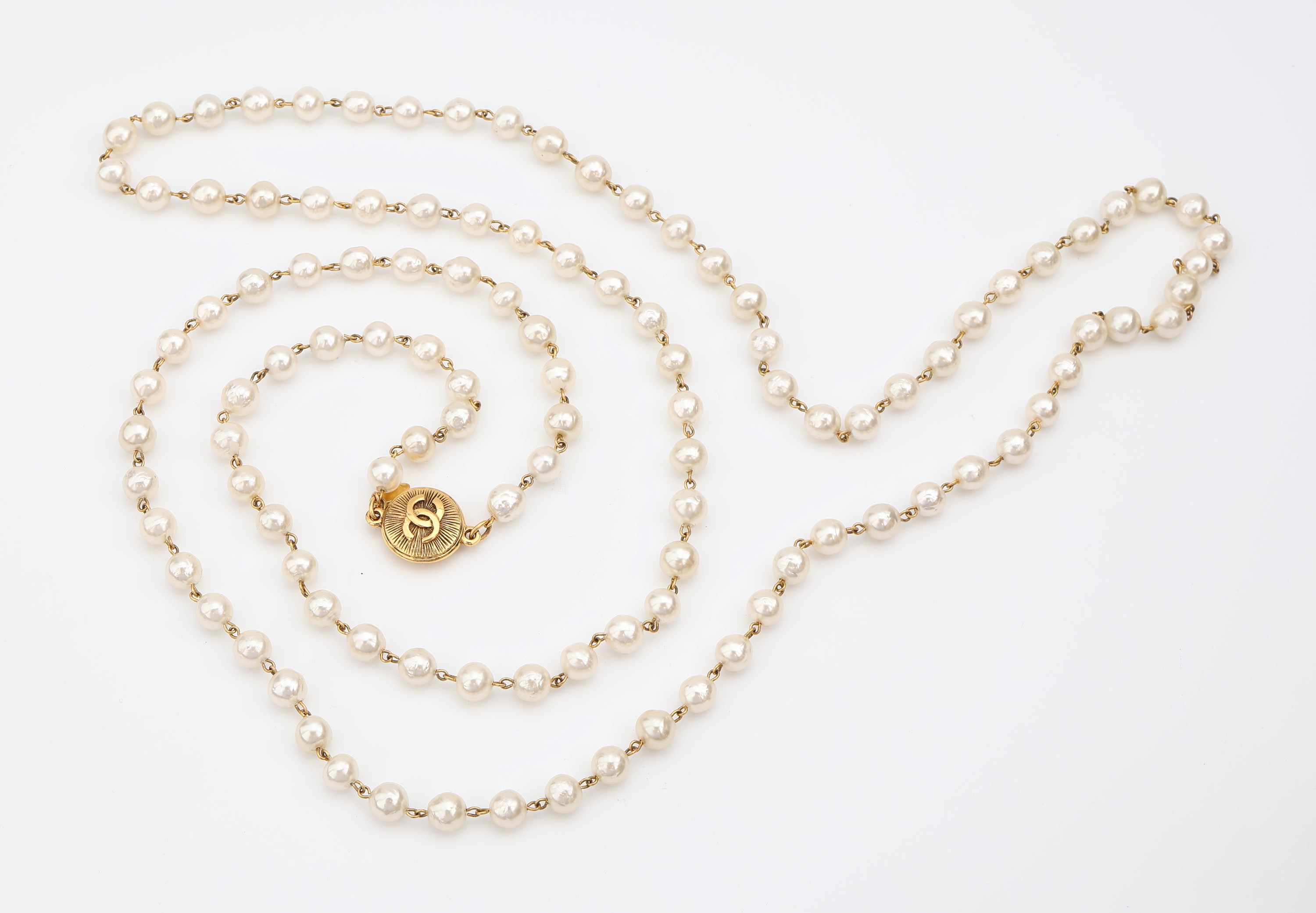Detail a: Überlanges CHANEL Modeschmuckcollier aus Kunstperlen, Paris, weiße Kunstperlen ca. 10 mm, Monturen und Chanel Emblem Metall verg., endlos, L. ca. ...