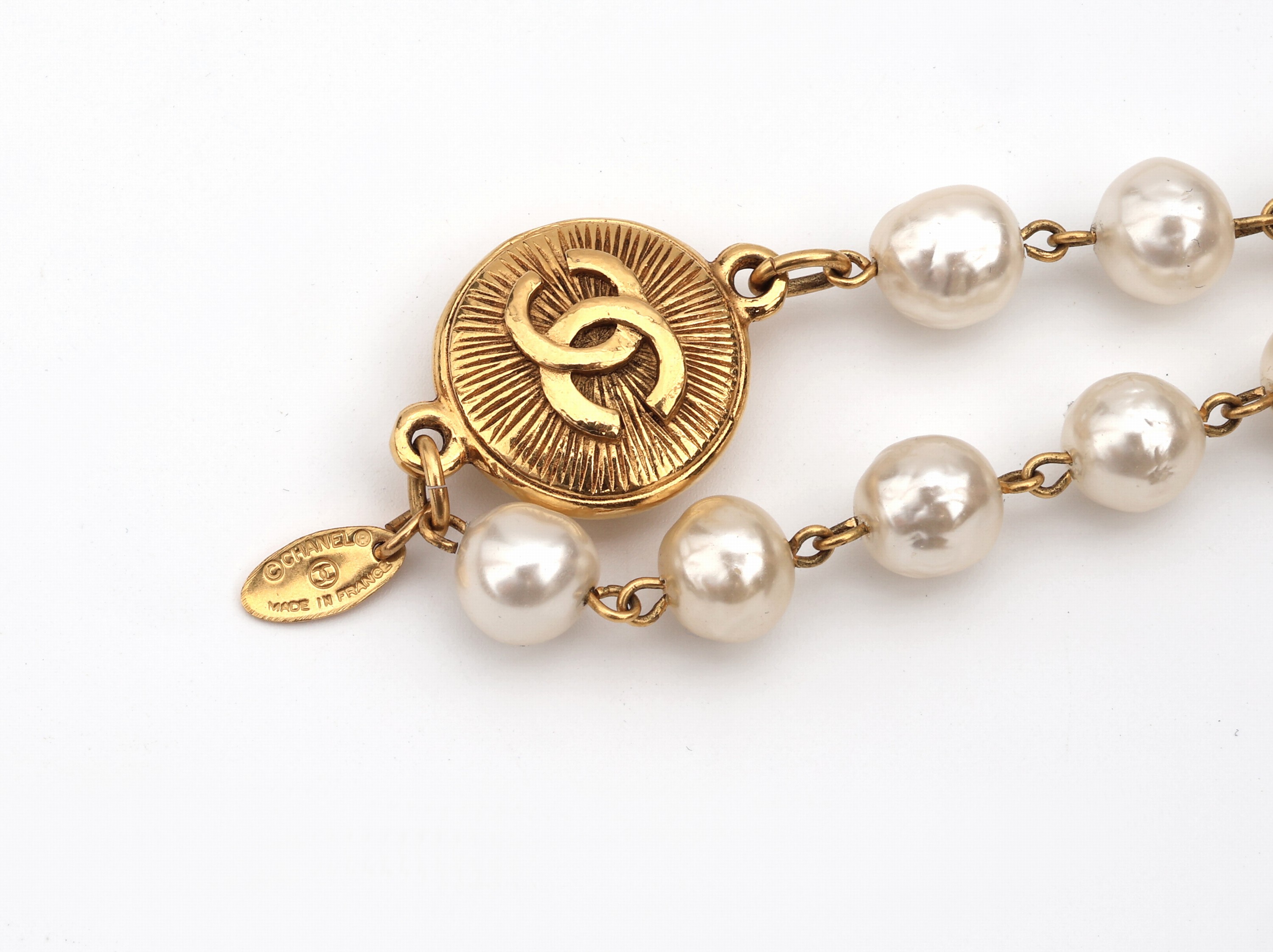 Detail b: Überlanges CHANEL Modeschmuckcollier aus Kunstperlen, Paris, weiße Kunstperlen ca. 10 mm, Monturen und Chanel Emblem Metall verg., endlos, L. ca. ...