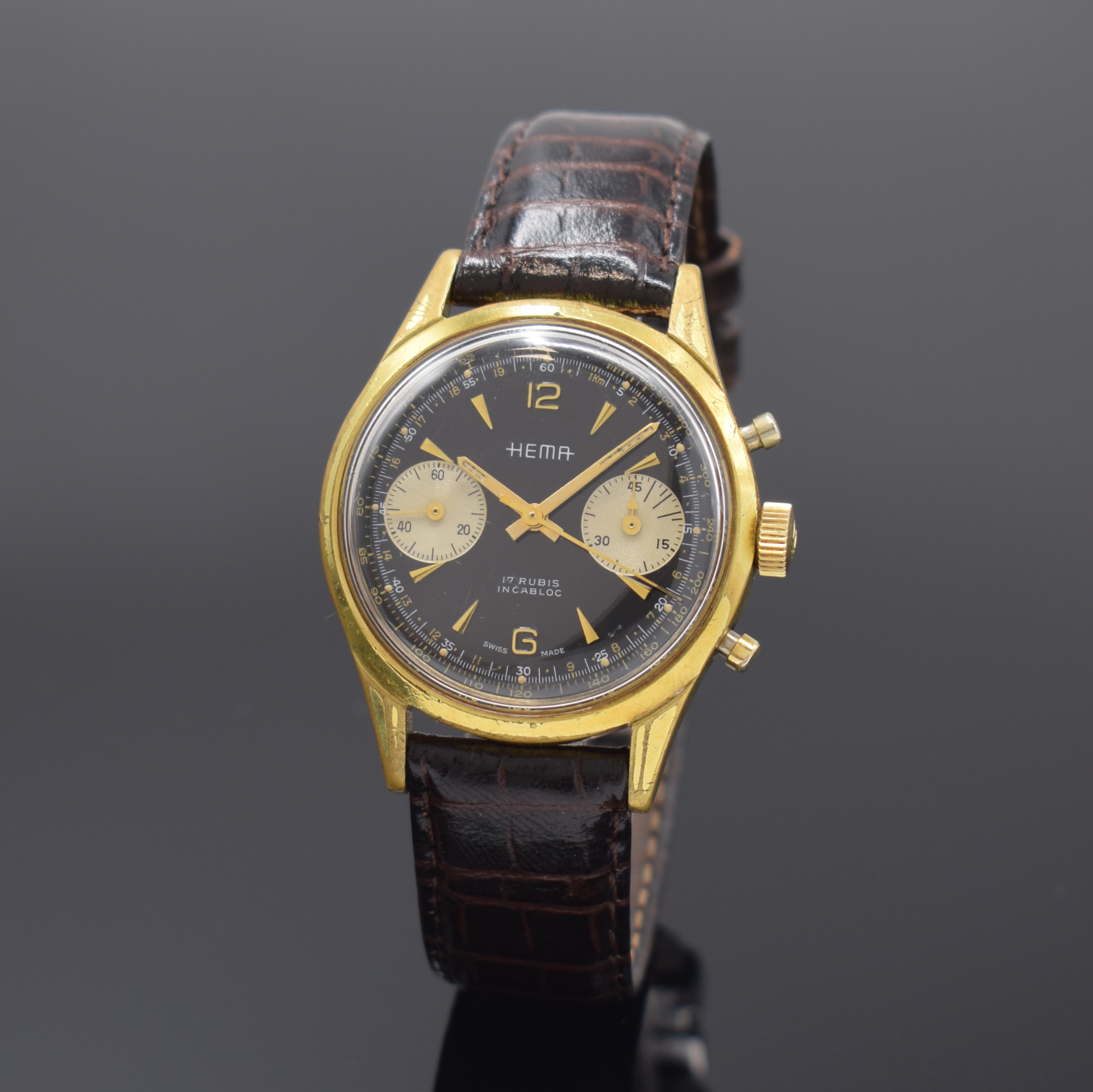 HEMA vergoldeter Armbandchronograph, Schweiz um 1965, Handaufzug, Stahlboden verschr., neutr. Lederband m. dopp. Faltschl., schwarzes Zifferbl. m. ...