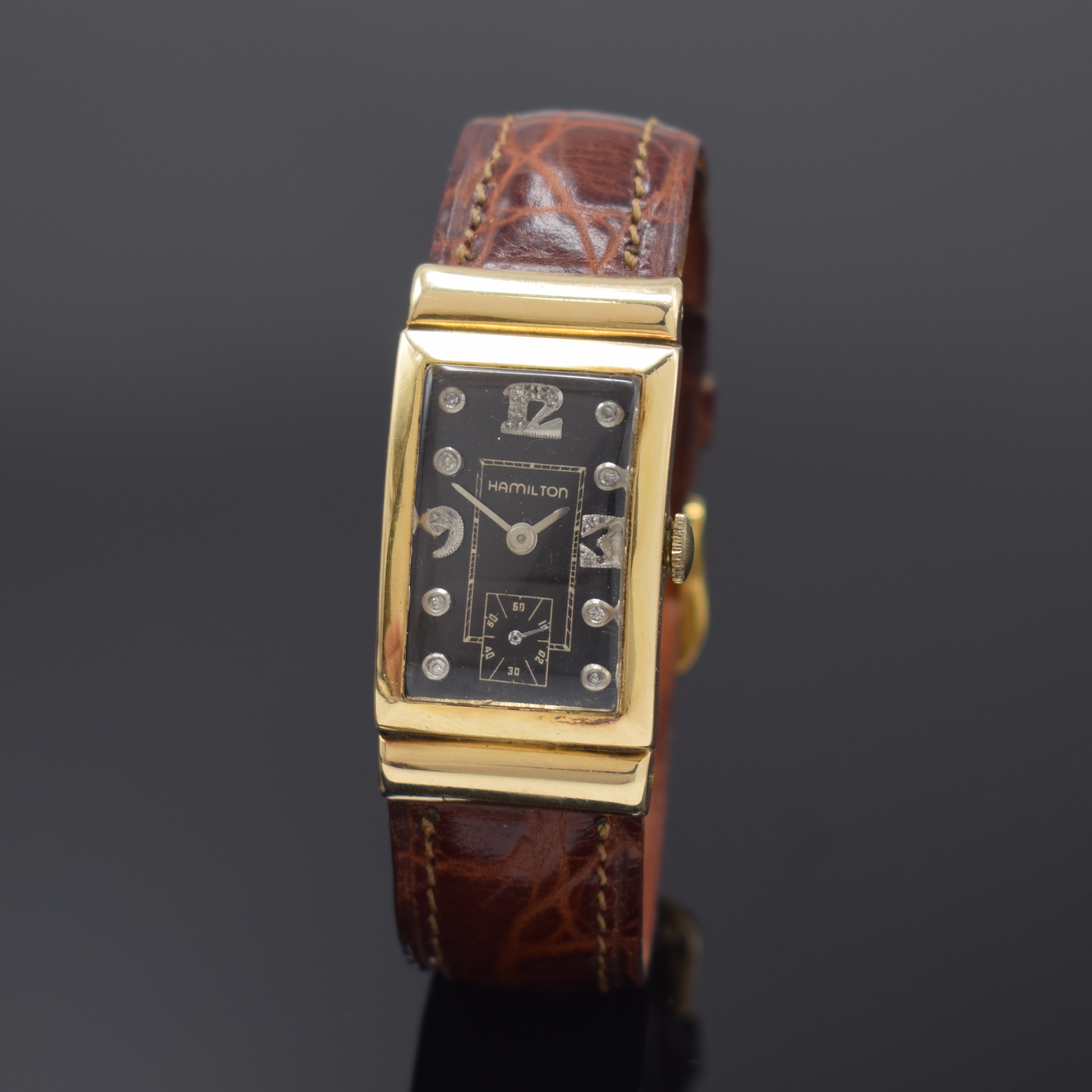 HAMILTON Armbanduhr in GG 585/000, USA um 1945, Handaufzug, neutrales Geh., Boden aufgedr., verd. Bandanst., schwarzes mit Diamanten bes. Zifferbl. ...