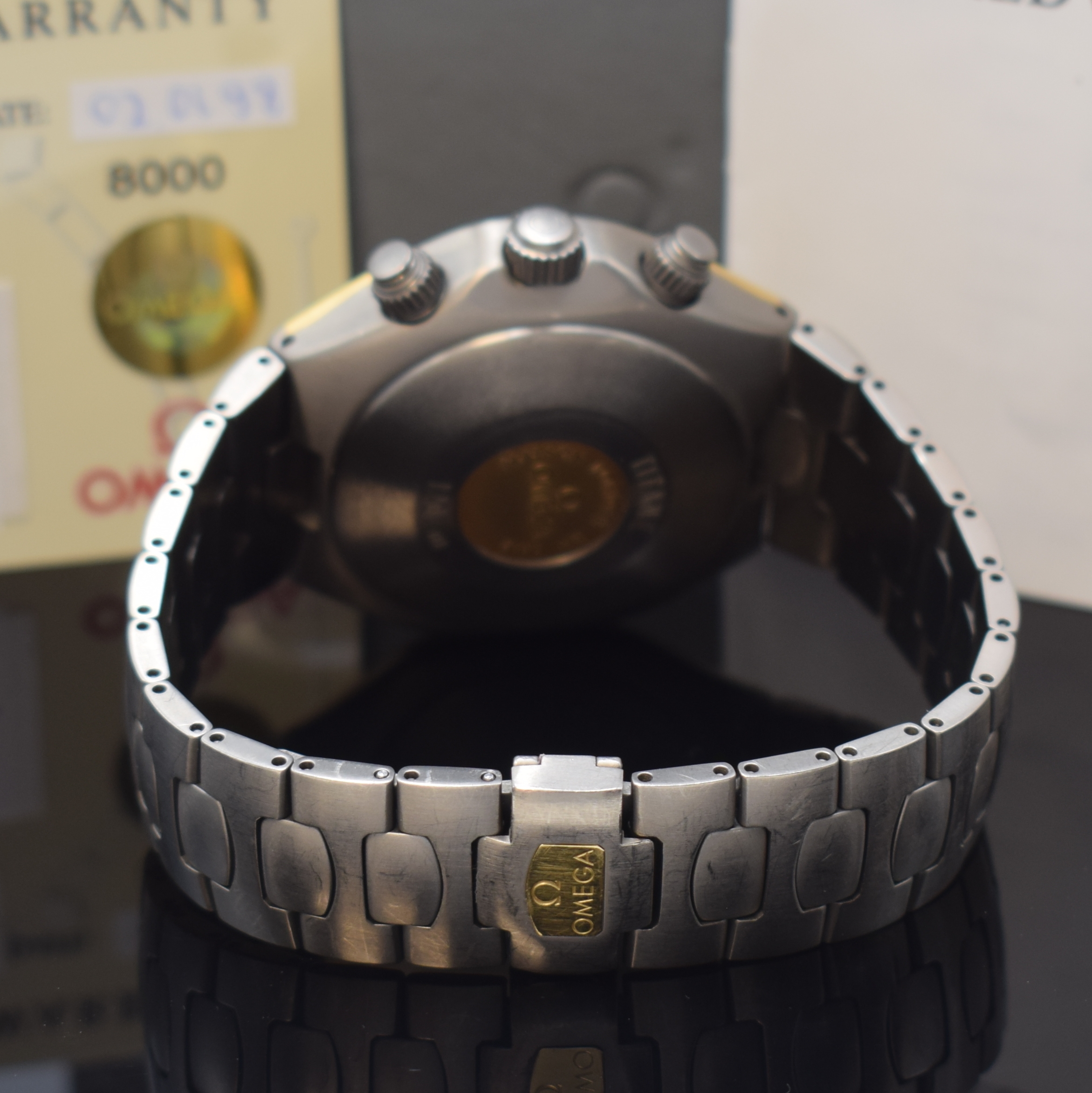 Detail b: OMEGA Armbandchronograph Titane Referenz 58944000, Automatik, Chronometer in Titan inkl. Titanband m. dopp. Faltschl., Boden m. Goldlogo aufgedr., ...
