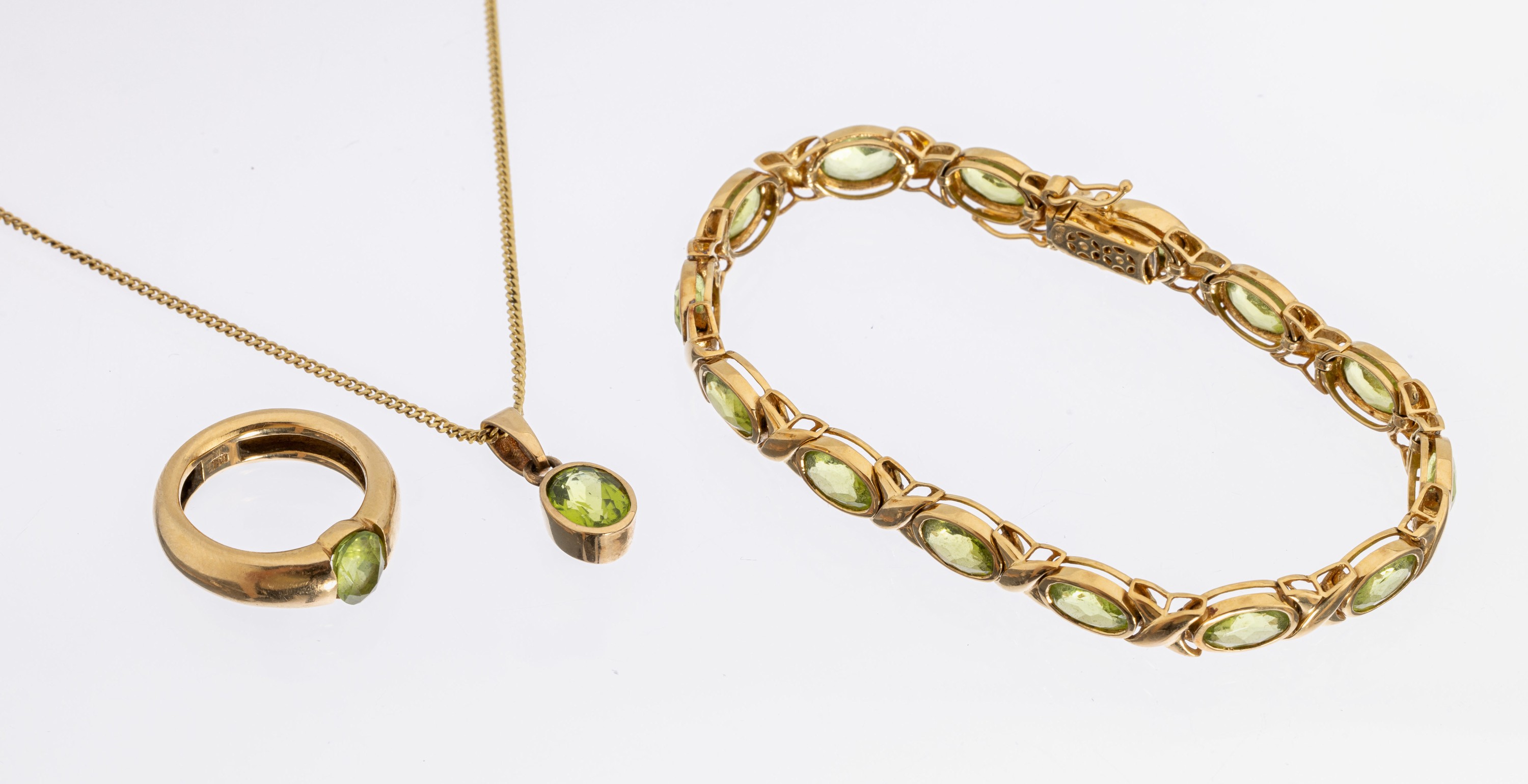 18 kt Gold Peridot-Schmuckset, GG 750/000, best. aus: Ring, Armband und Anhänger, insg. 16 ovalfacett. Peridots zus. ca. 30.0 ct, RW 54, Armband L. ...