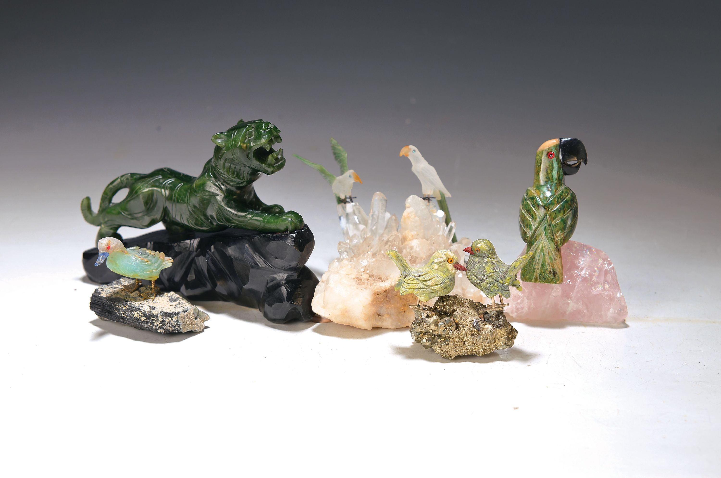 5 Halbedelsteinfiguren, Mitte 20. Jh., Vogeldarstellungen, Papagei auf Rosenquarz sitzend, Taubenpaar, Ente und 2 Papageien auf Bergkristall sitzend, ...