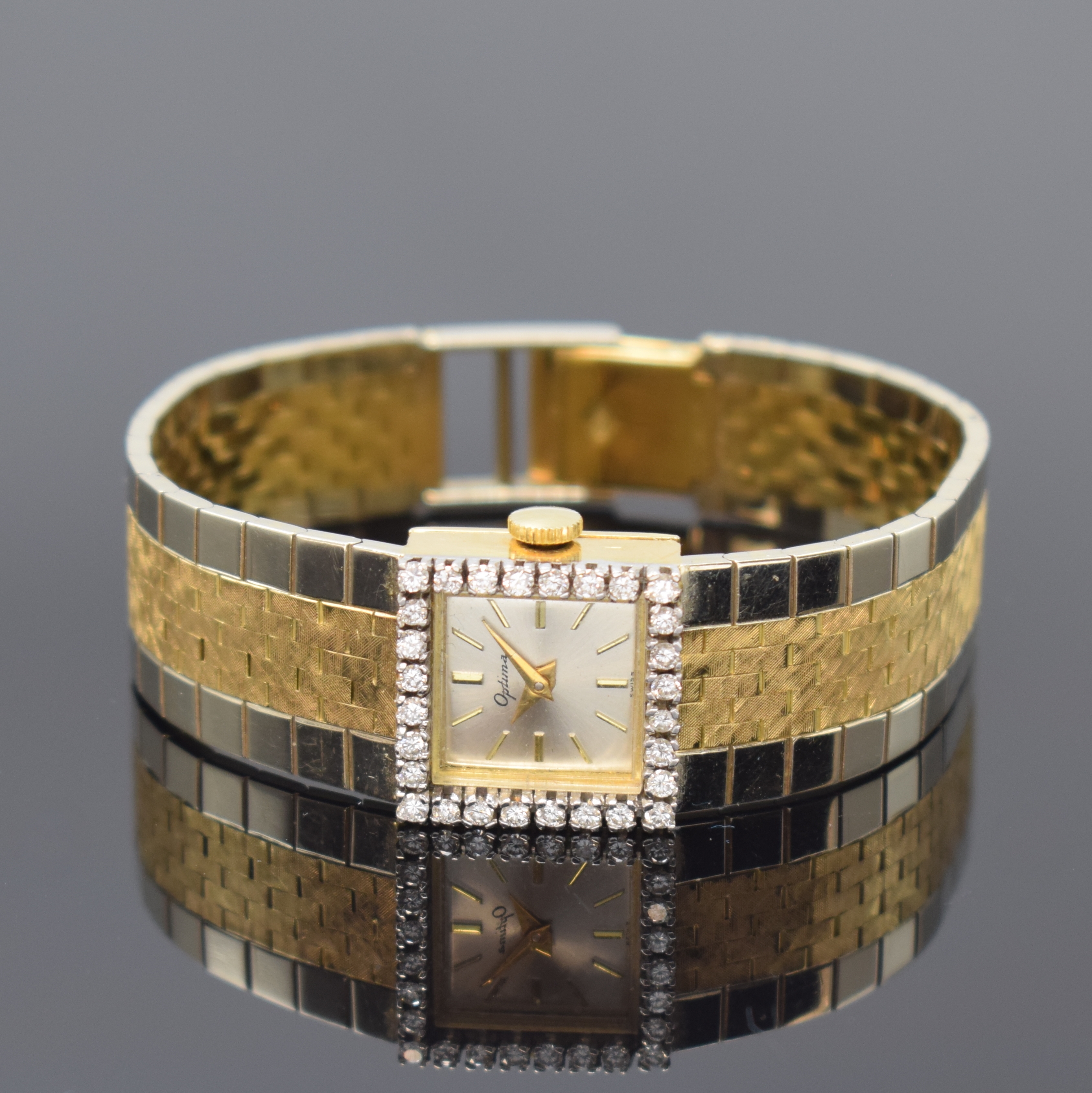 OPTINA Diamantbesetzte Damenarmbanduhr in GG/WG 750/000, Schweiz um 1965, Handaufzug, quadrat. Geh., Boden aufgedr., anges. orig. Band in WG/GG ...