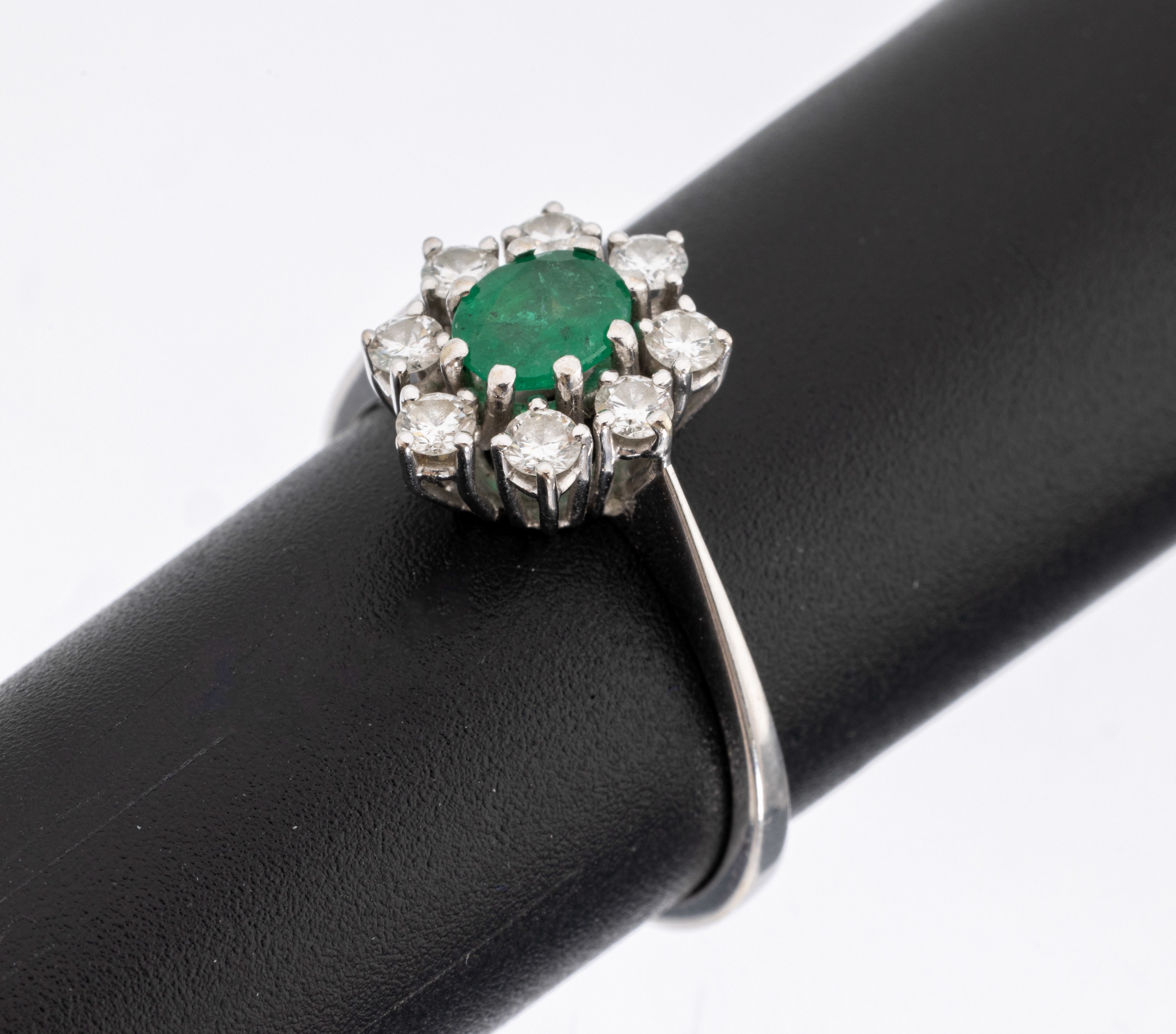 14 kt Gold Smaragd-Brillant-Ring, WG 585/000, mittig ovalfacett. Smaragd ca. 0.36 ct (grav.), umgeben von 8 Brillanten zus. ca. 0.44 ct (grav.) ...