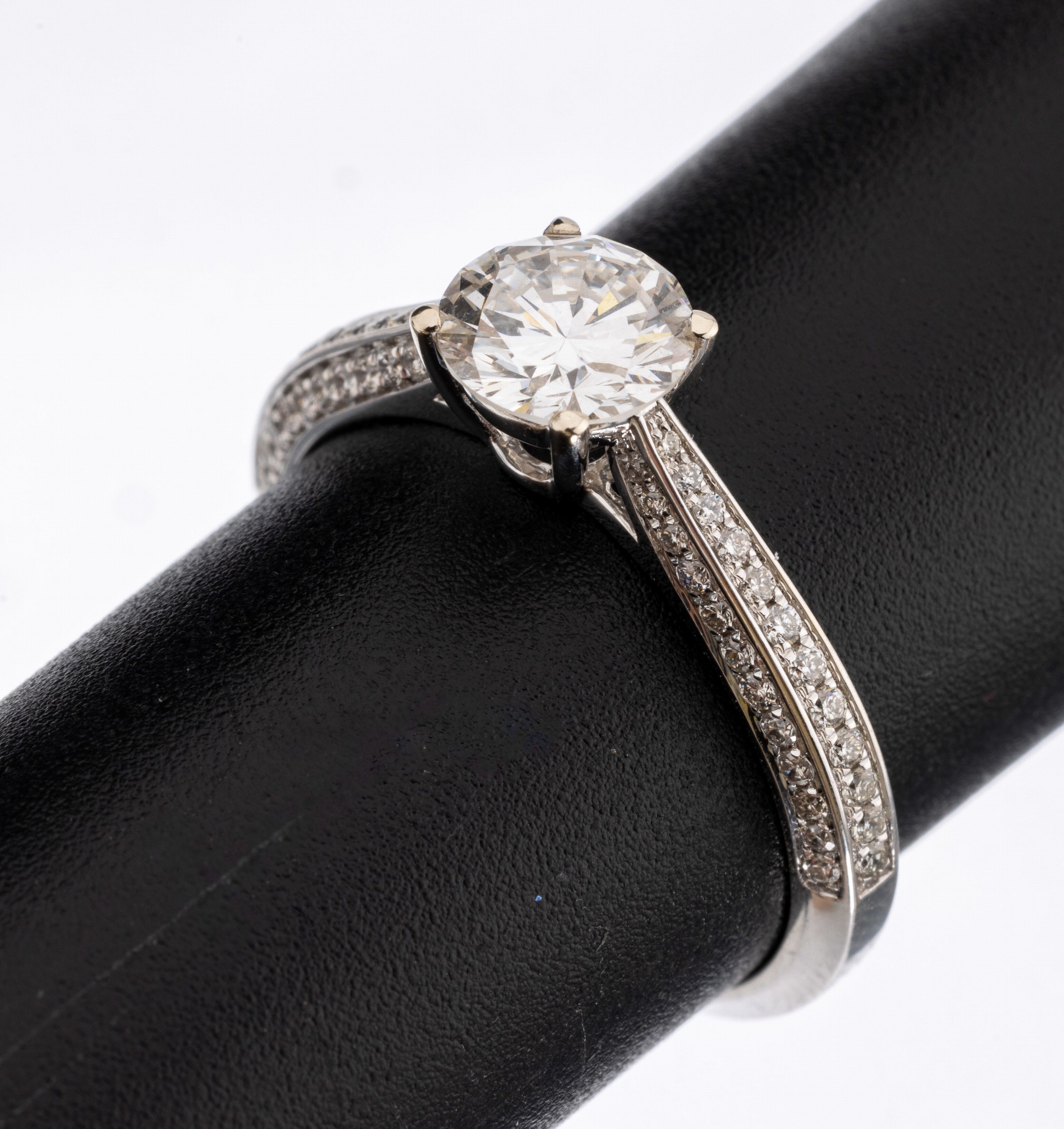 18 kt Gold Brillant-Ring, WG 750/000, mittig erhaben gefasster Brillant ca. 1.01 ct feines Weiß(G)/lr, 72 Brillanten zus. ca. 0.36ct feines ...