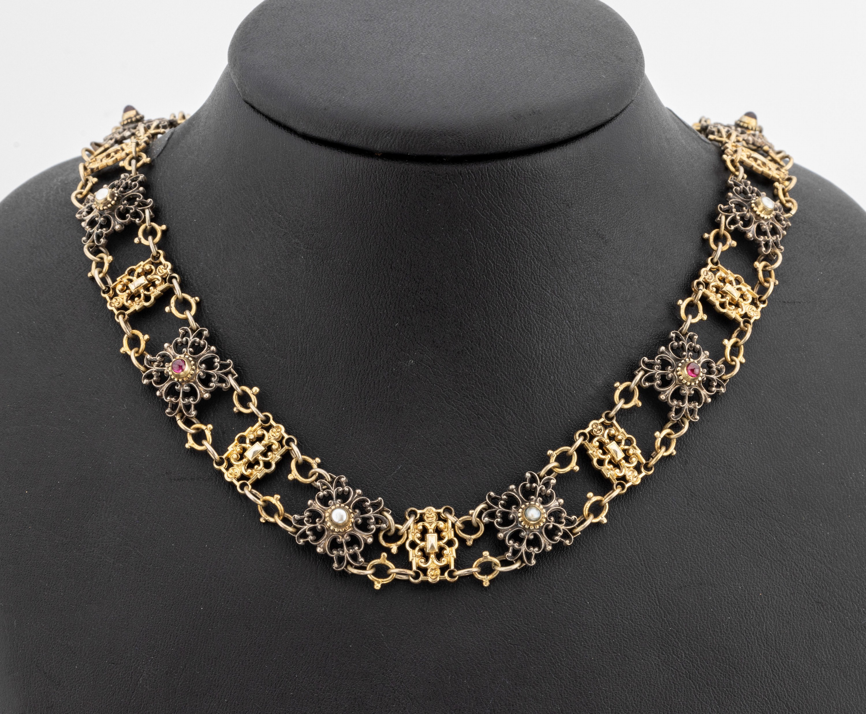 Trachten-Collier, wohl Österreich um 1900, Silber gepr., teils vergoldet, geschwungene Glieder, teilw. mit Glassteinen und Flussperlen, L. ca. 53 ...