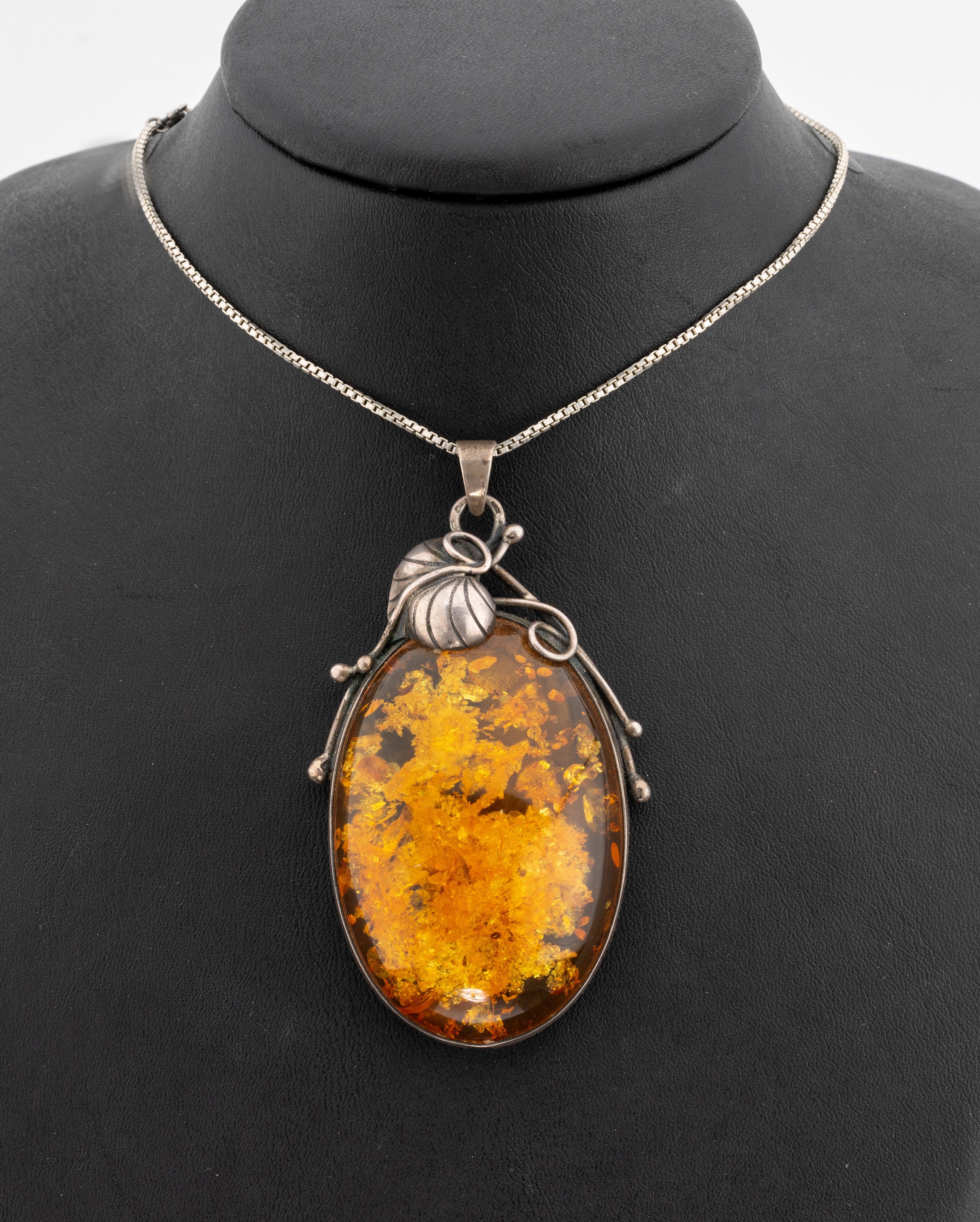 Großer Bernsteinanhänger, 800er Silber, Bernsteincabochon mit Inclusen, Blattverzierung, L. ca. 8 cm, an Kette 925er Silber, L. ca. 53 cm, ...