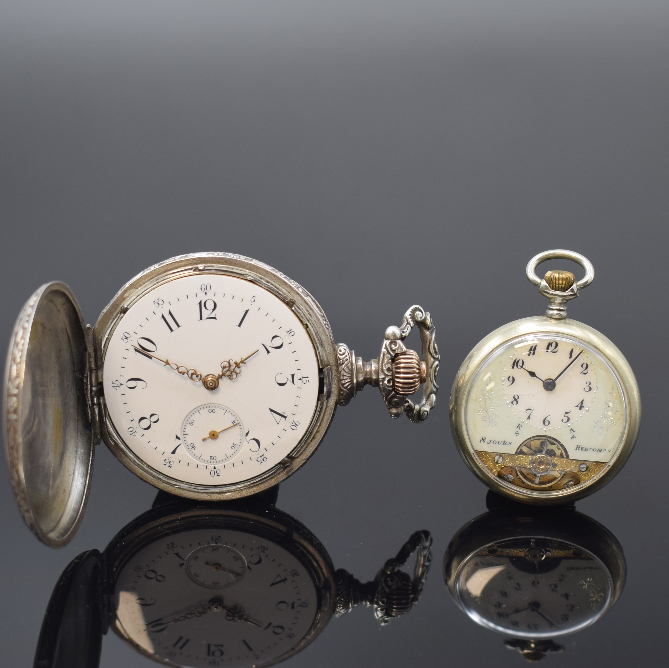 HEBDOMAS 8-Tage Taschenuhr und eine Savonette, Schweiz um 1905/1915, 1) Hebdomas offene Taschenuhr m. grav. Rückdeckel, Zifferbl. riss., arab. ...