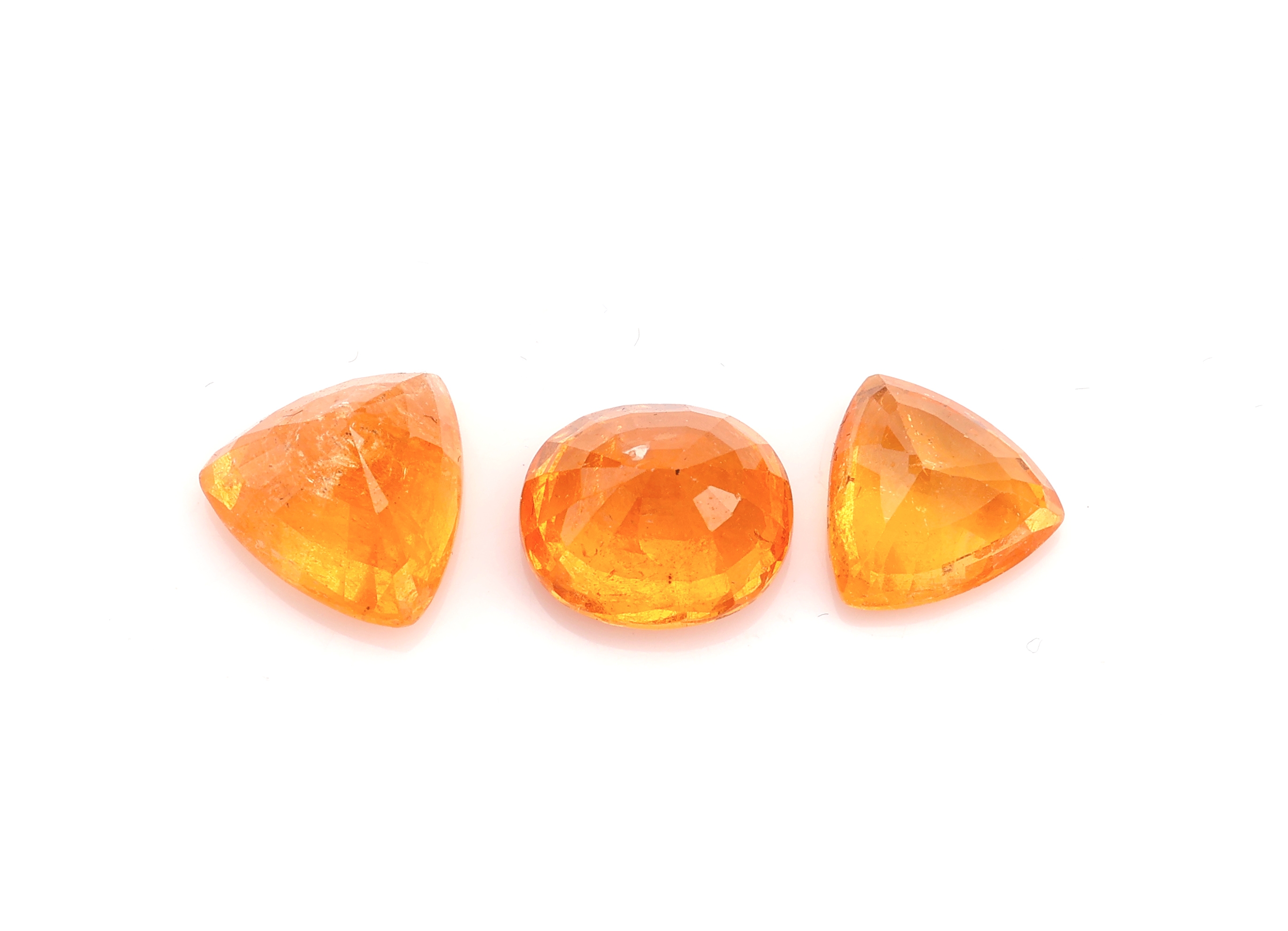 Detail a: Lot lose Mandaringranate, zus. ca. 7.44 ct, 2 x Triangel, 1 x ovalfacett.
