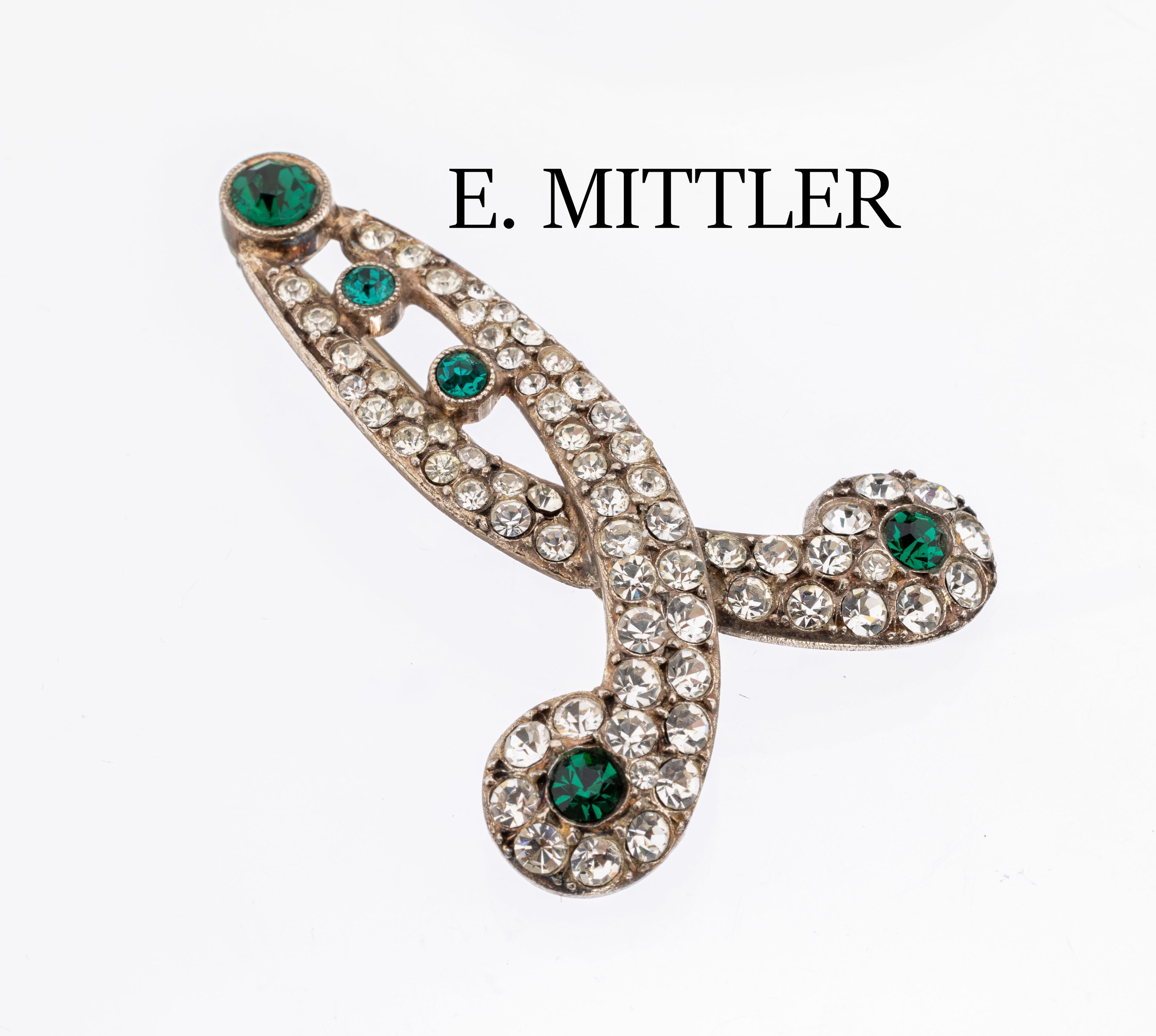 Schleifenbrosche, Frankreich um 1925/28, Entwurf und Hersteller E. MITTLER, Paris, Metall versilbert, farbloser und grüner Straßbesatz, symm. ...