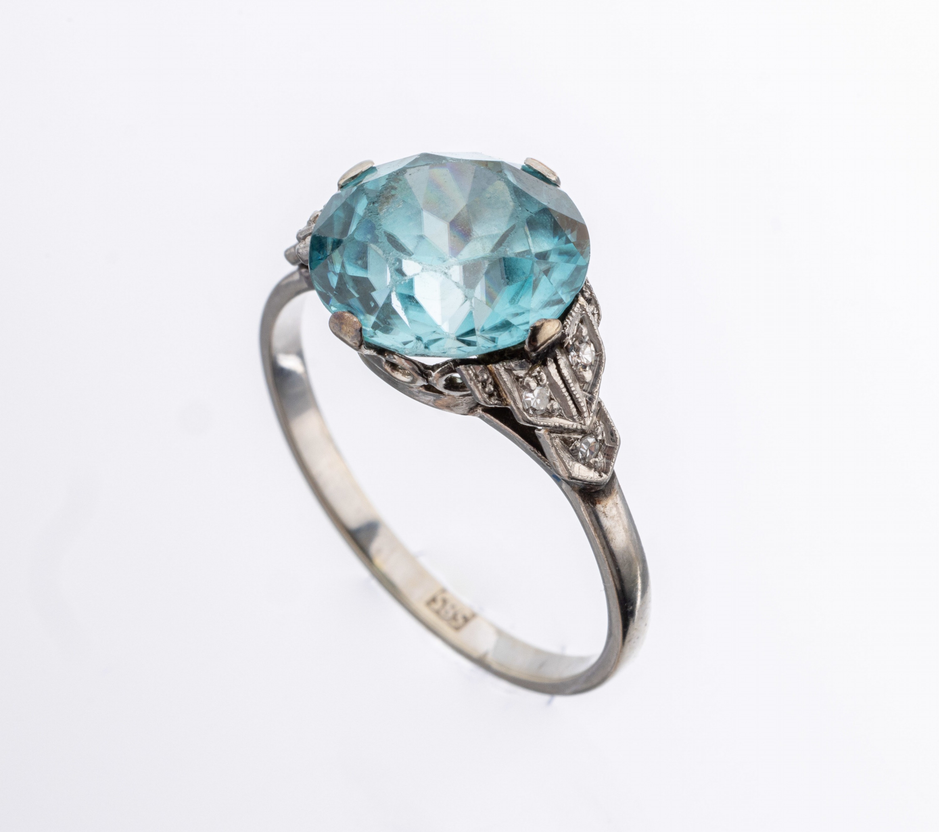 14 kt Gold Zirkon-Diamant-Ring, um 1930, WG585/000, mittig rundfacett. blauer Zirkon ca. 4.50 ct, Facetten stark berieben, Ringschultern mit 6 ...