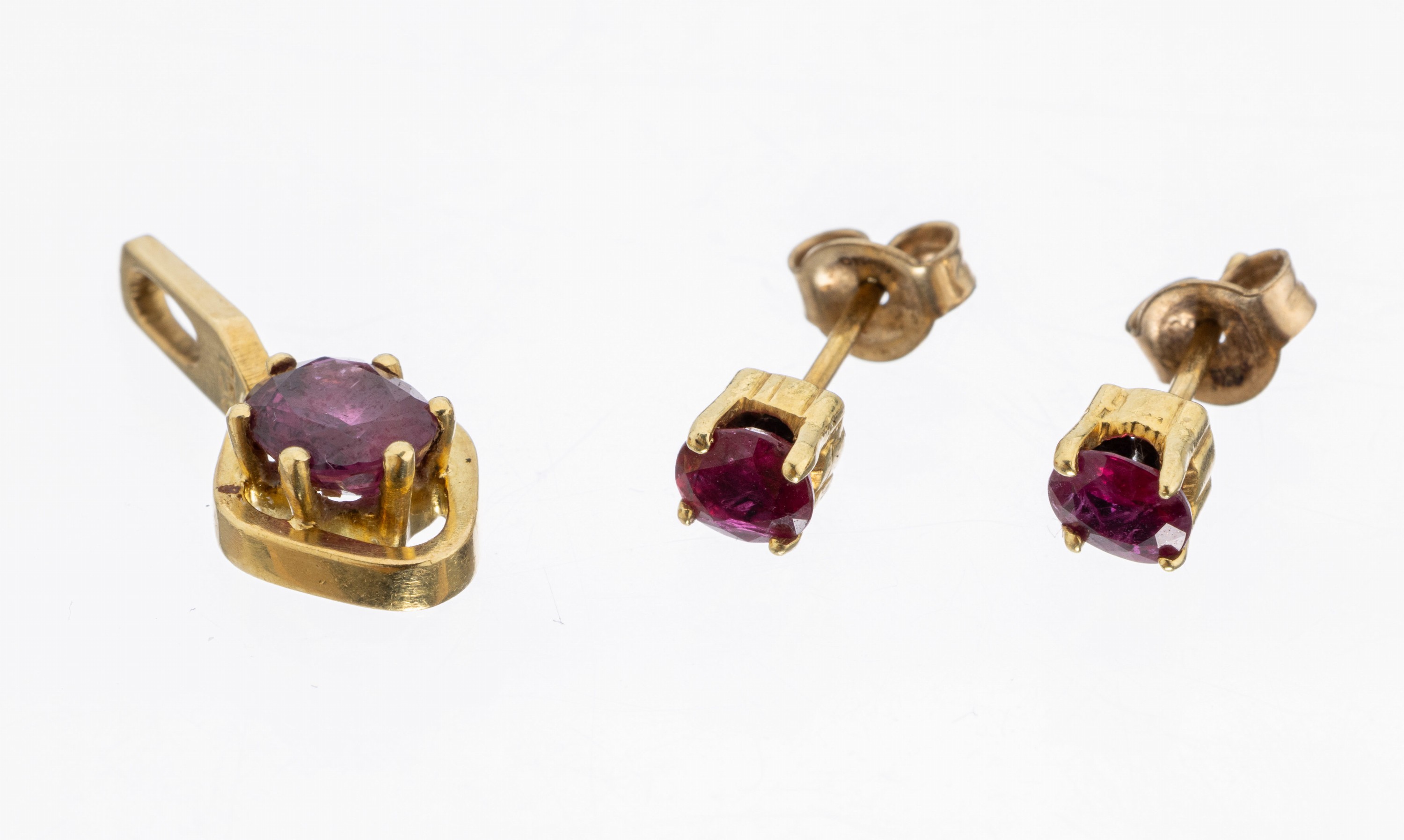 18 kt Gold Rubin-Schmuckset, GG 750/000, best. aus: 1 Anhänger, ovalfacett. Rubin ca. 0.90 ct, 1 Paar Ohrstecker, 2 ovalfacett. Rubine zus. ca. ...