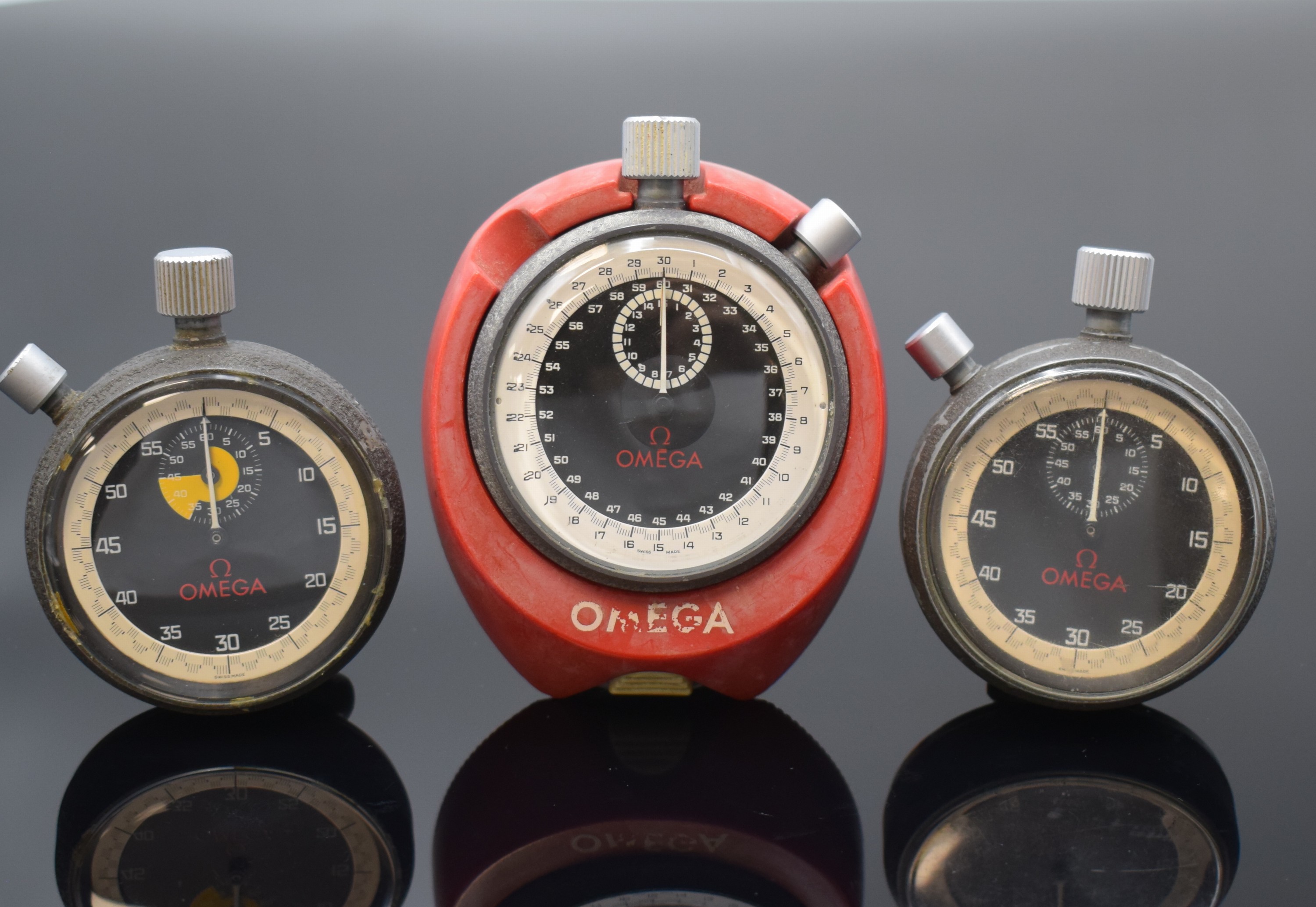 OMEGA 3 Stoppuhren, Schweiz um 1965, Handaufzug, Metallgeh., schwarz lack. berieb., verschr. Stahlböden, schwarz. Zifferblätter m. weißer ...
