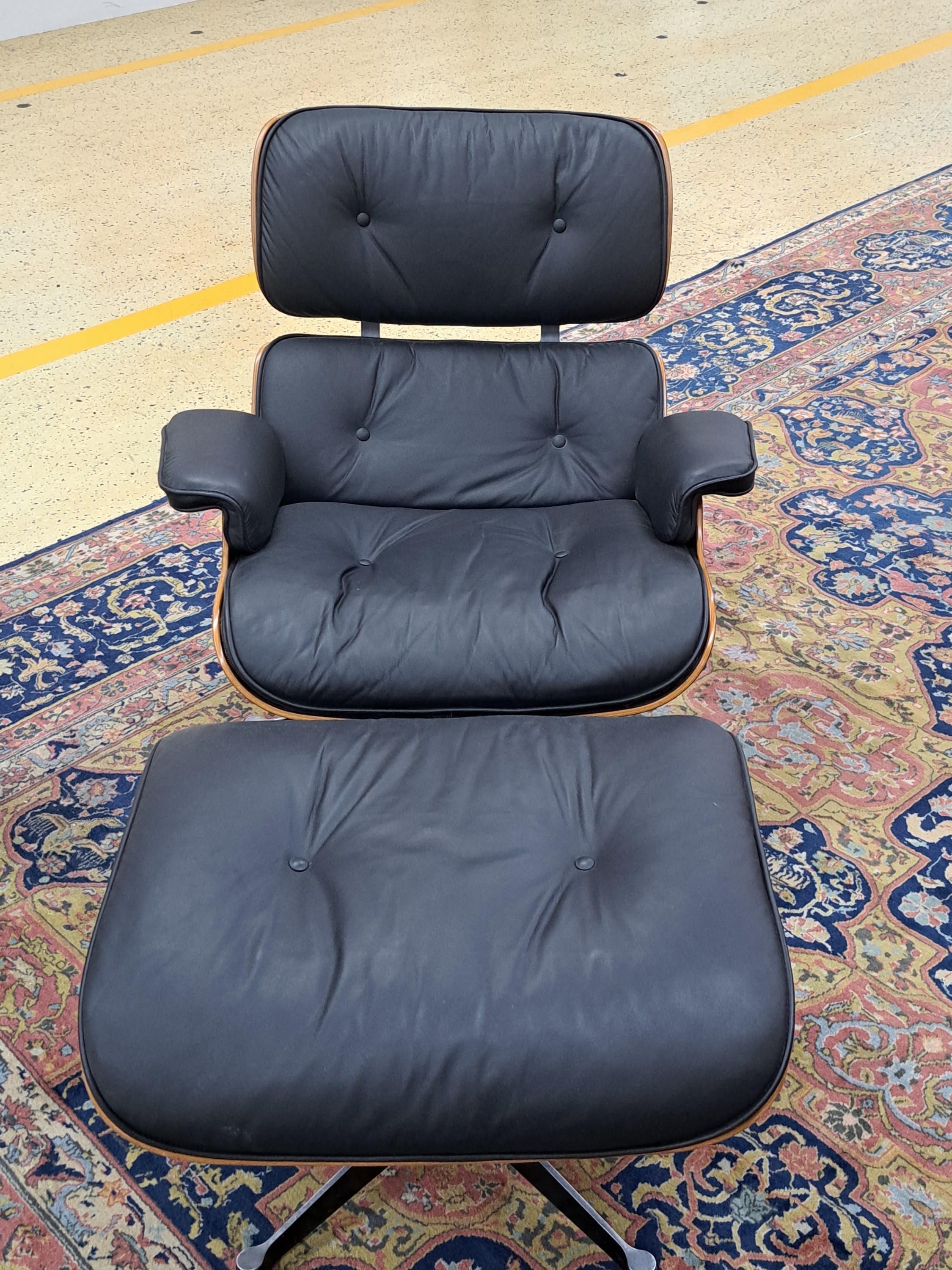Detail a: Lounge Chair mit Ottomane, Entwurf Charles und Ray Eames, Ausführung Vitra, Entwurf von 1956, Polsterung im schwarzen Leder, diese vor 10 Jahren ...