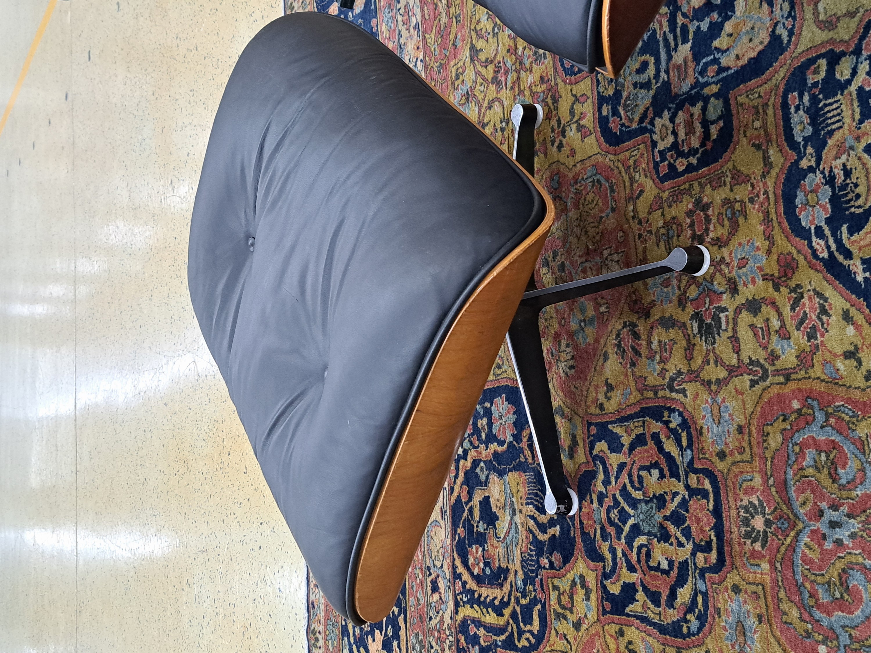 Detail c: Lounge Chair mit Ottomane, Entwurf Charles und Ray Eames, Ausführung Vitra, Entwurf von 1956, Polsterung im schwarzen Leder, diese vor 10 Jahren ...