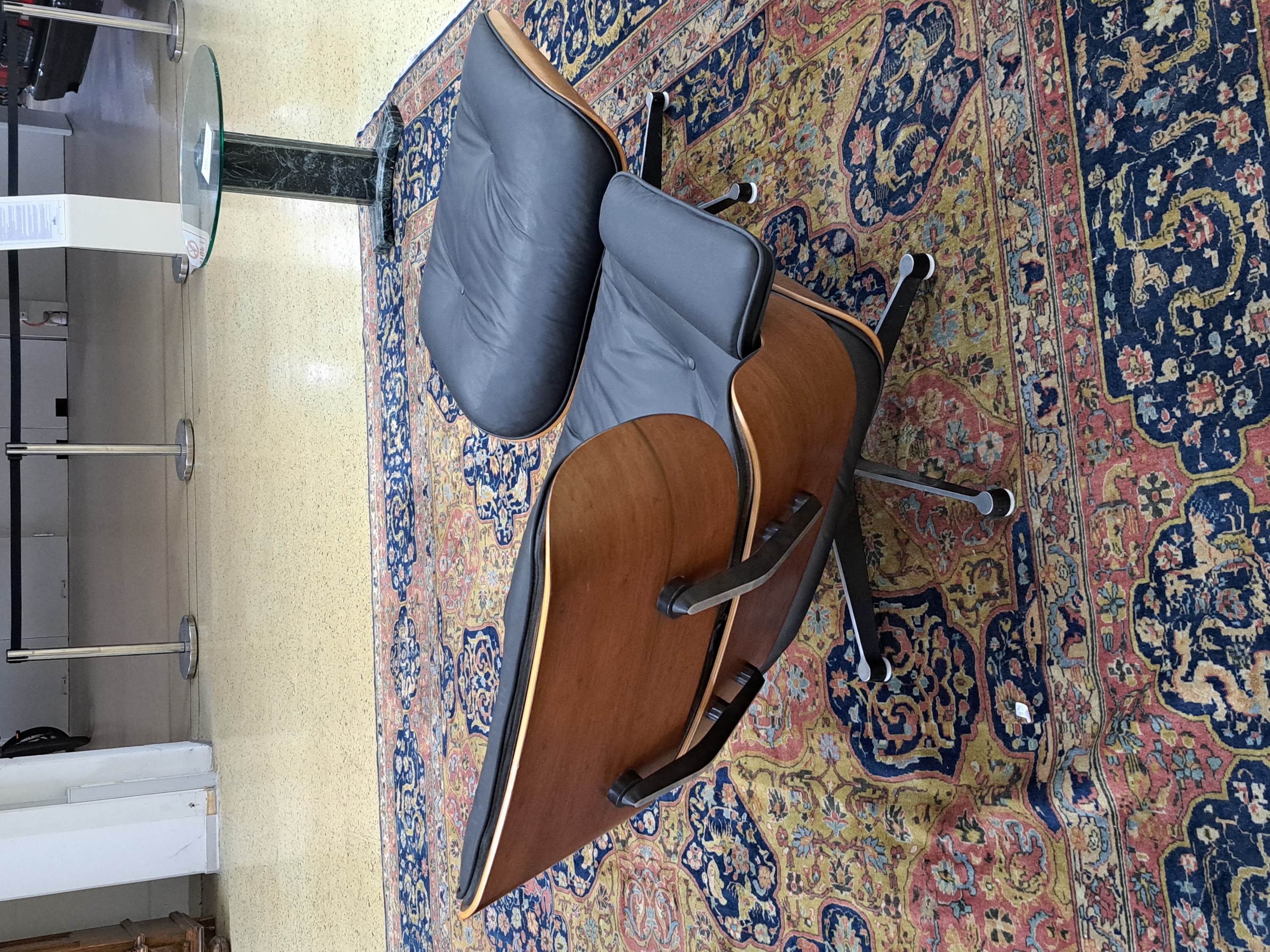 Detail d: Lounge Chair mit Ottomane, Entwurf Charles und Ray Eames, Ausführung Vitra, Entwurf von 1956, Polsterung im schwarzen Leder, diese vor 10 Jahren ...
