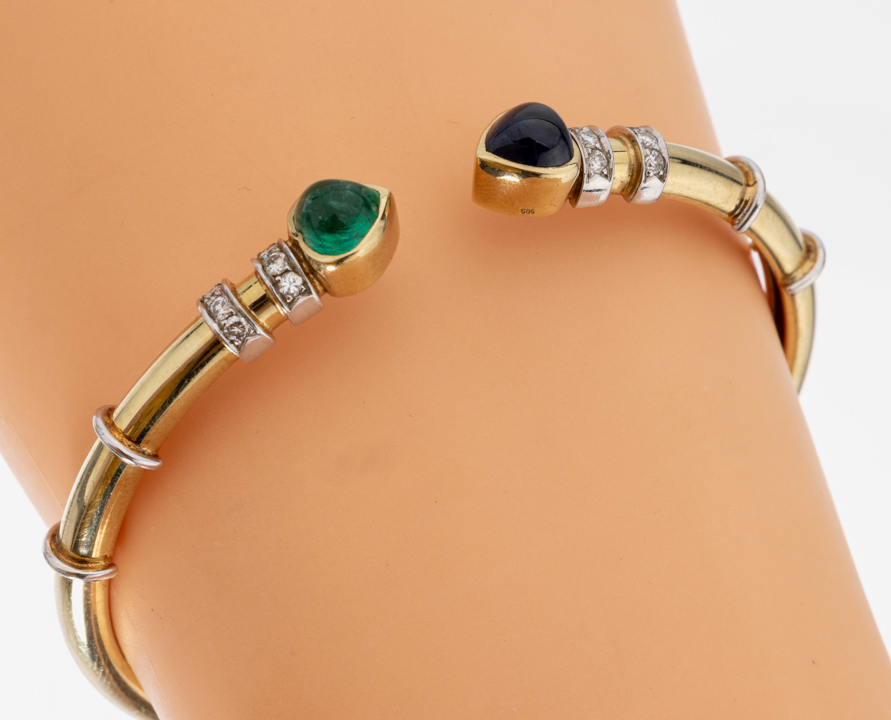 14 kt Gold Farbstein-Brillant-Armspange, GG/WG 585/000, 1 herzförmiges Saphir- und Smaragd-Cabochon zus. ca. 3.00 ct, 12 in WG gefasste Brillanten ...