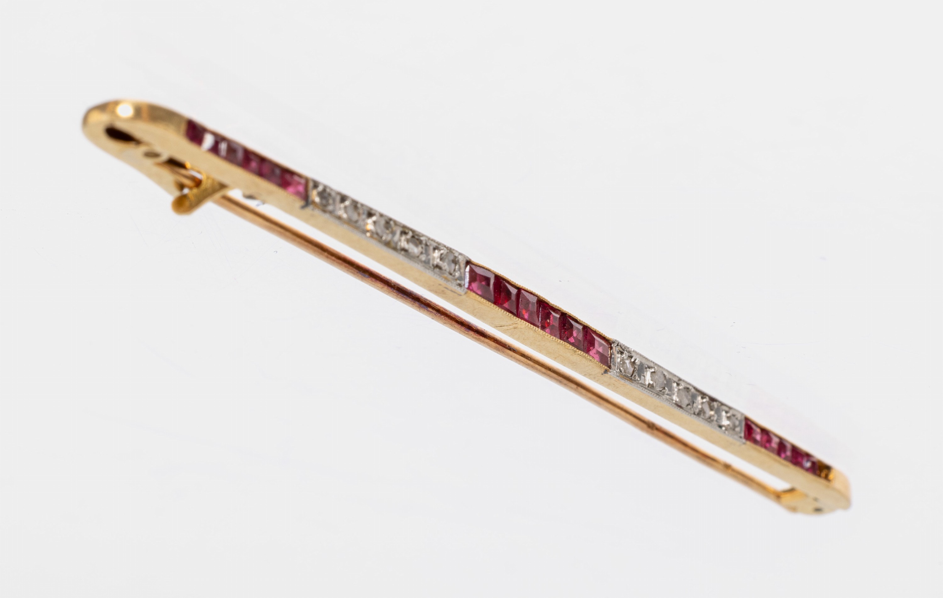 14 kt Gold Rubin-Diamant-Brosche, um 1920, GG 585/000, länglich, 17 Rubin-Carrees zus. ca. 0.20 ct, 1 Stein fehlt, 10 kl. Diamantrosen, L. ca. 7 ...