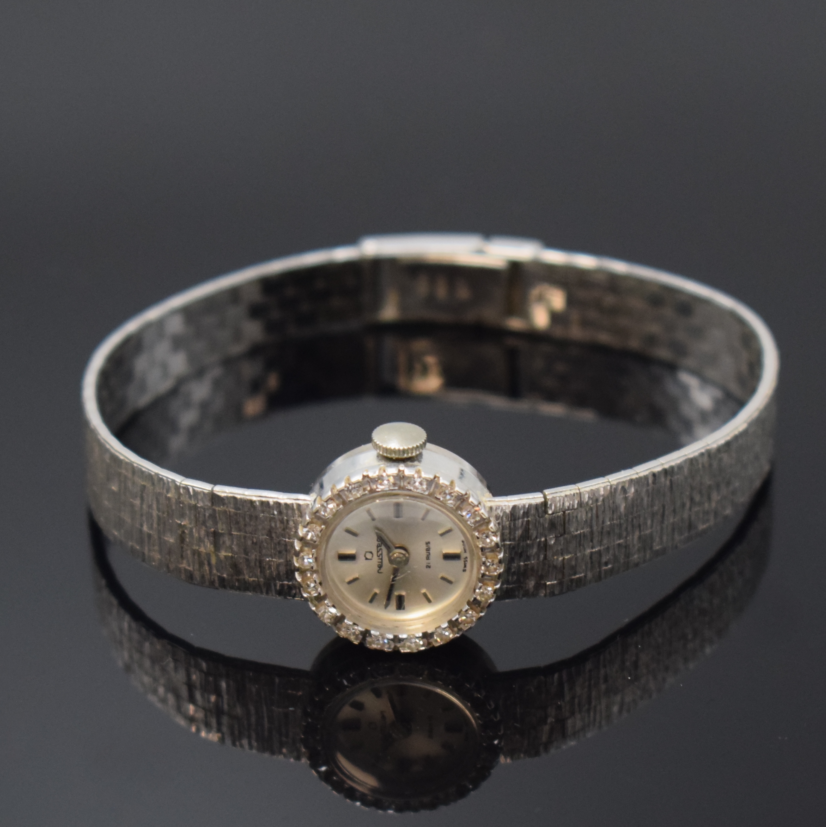 REUSSER diamantbesetzte Damenarmbanduhr in WG 750/000, Schweiz um 1960, Handaufzug, 2- teil. Geh. m. aufgedr. Boden, anges. Band, silb. Zifferbl. m. ...