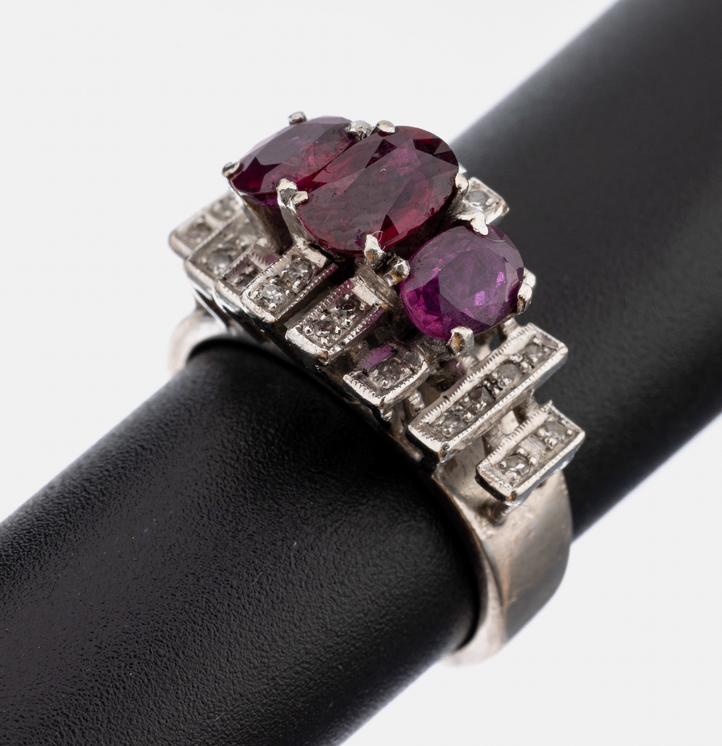 14 kt Gold Rubin-Diamant-Ring, WG 585/000 gepr., in 2 Ebenen aufgebaut, 24 8/8-Diamantenzus. ca. 0.12 ct l.get.Weiß/p, 3 ovalfacett. Rubine zus. ...
