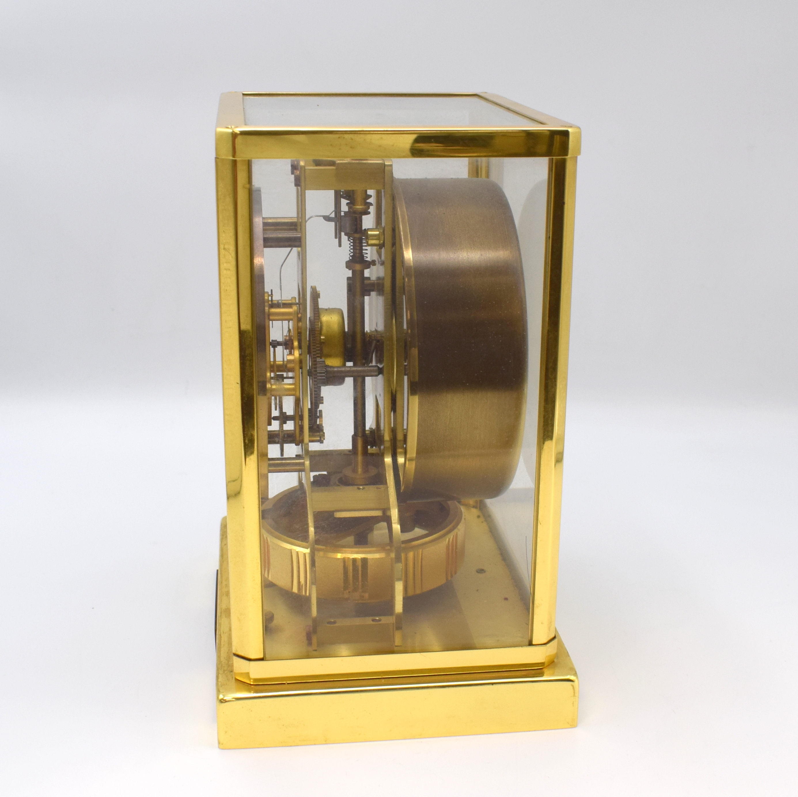 Detail e: LeCoultre Drehpendel-Tischuhr Atmos, Schweiz um 1965, verg., vergl. Geh., nach vorn zu öffnende Glastür zu ers., Sockel m. aufgebrachte Plakette, ...
