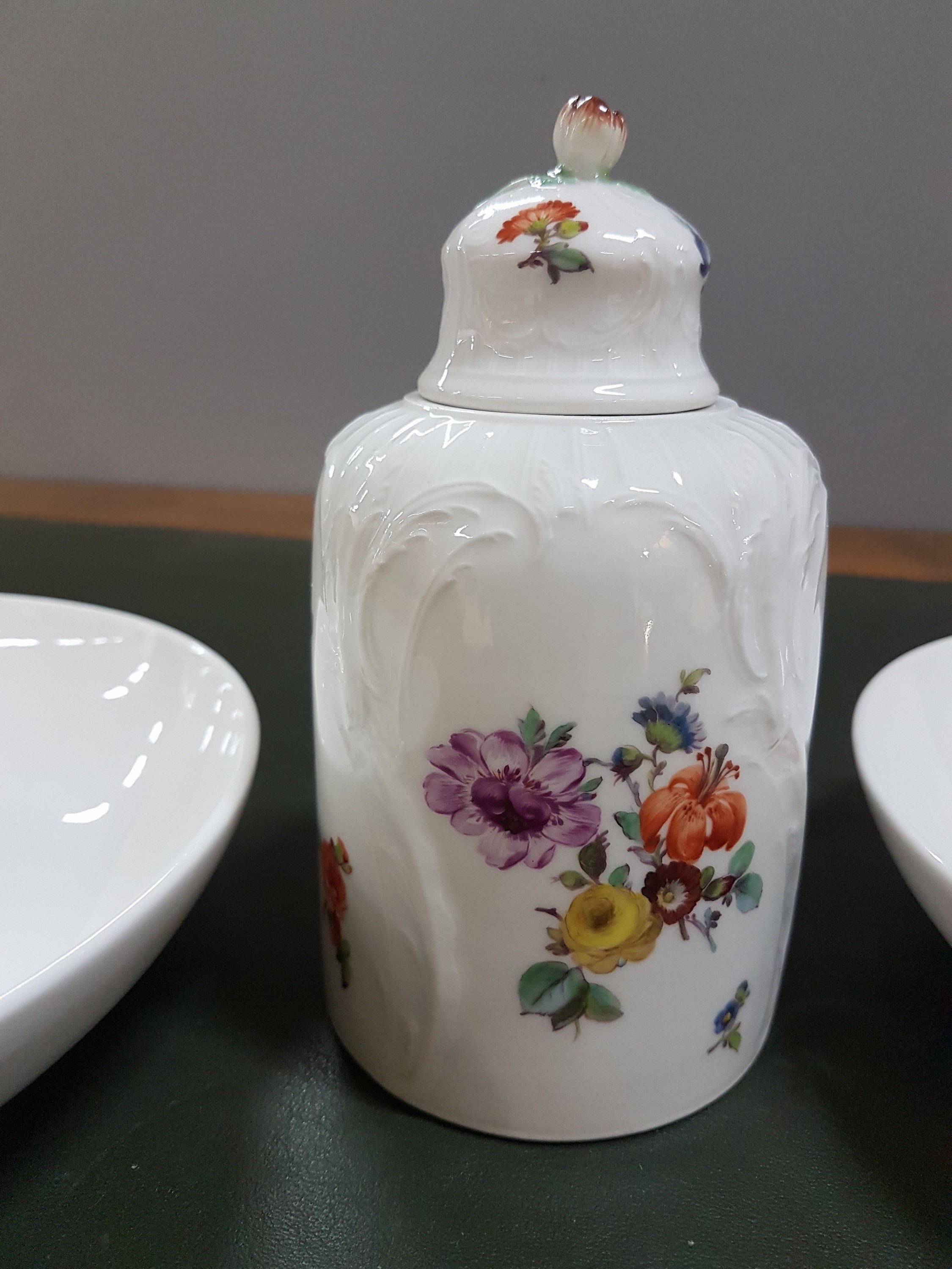 Detail b: Zwei Wandteller und eine Teedose, KPM Berlin, um 1909 - 1925, Teller mit feiner Blumenbukettmalerei, D. ca. 19 cm, Teedose Reliefzierrat, mit ...
