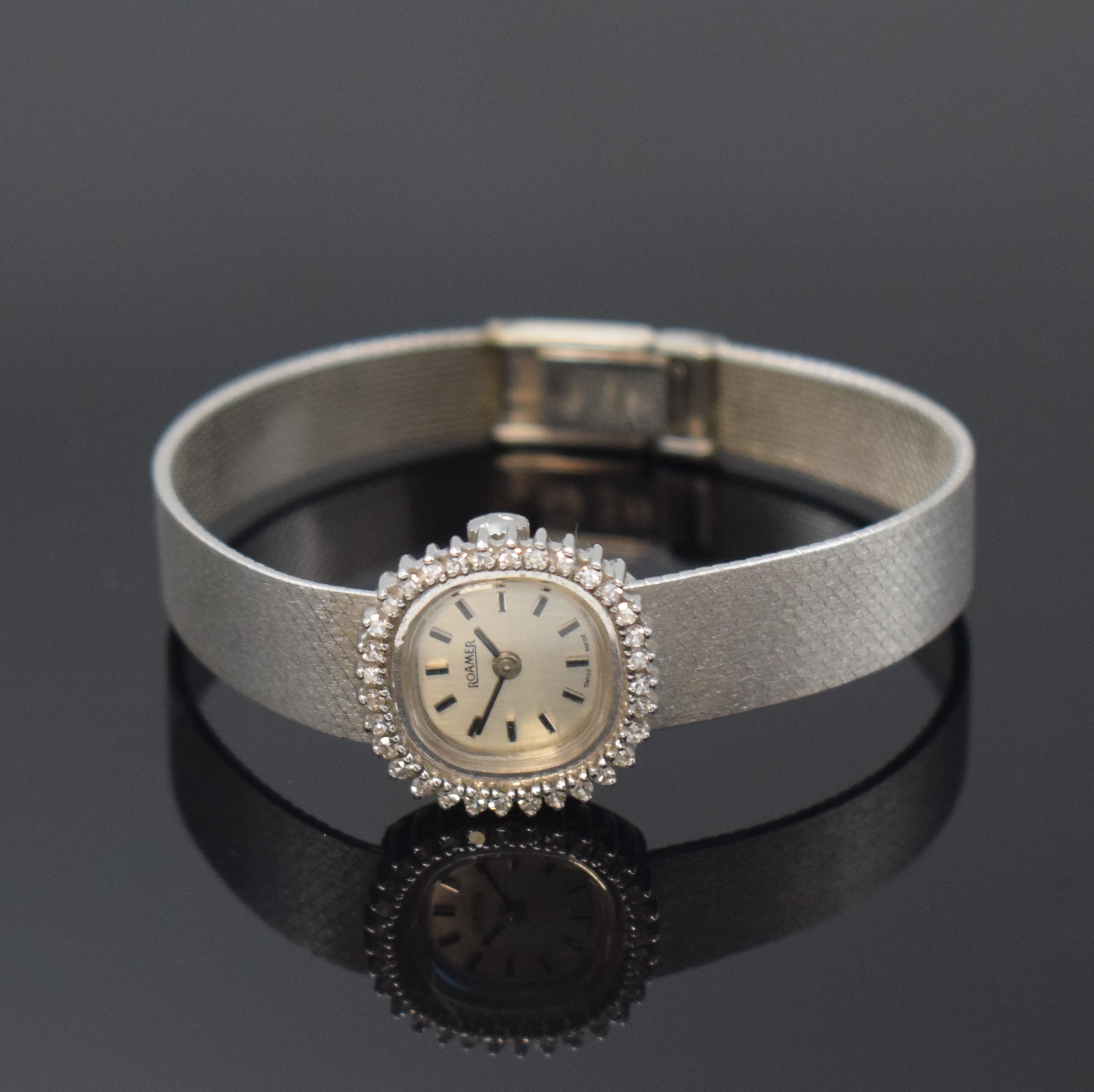 ROAMER Damenarmbanduhr in WG 585/000 mit Diamantlünette, Handaufzug, Schweiz um 1970, Boden aufgedr., Milanaiseband, silb. Zifferbl. m. aufgel. ...
