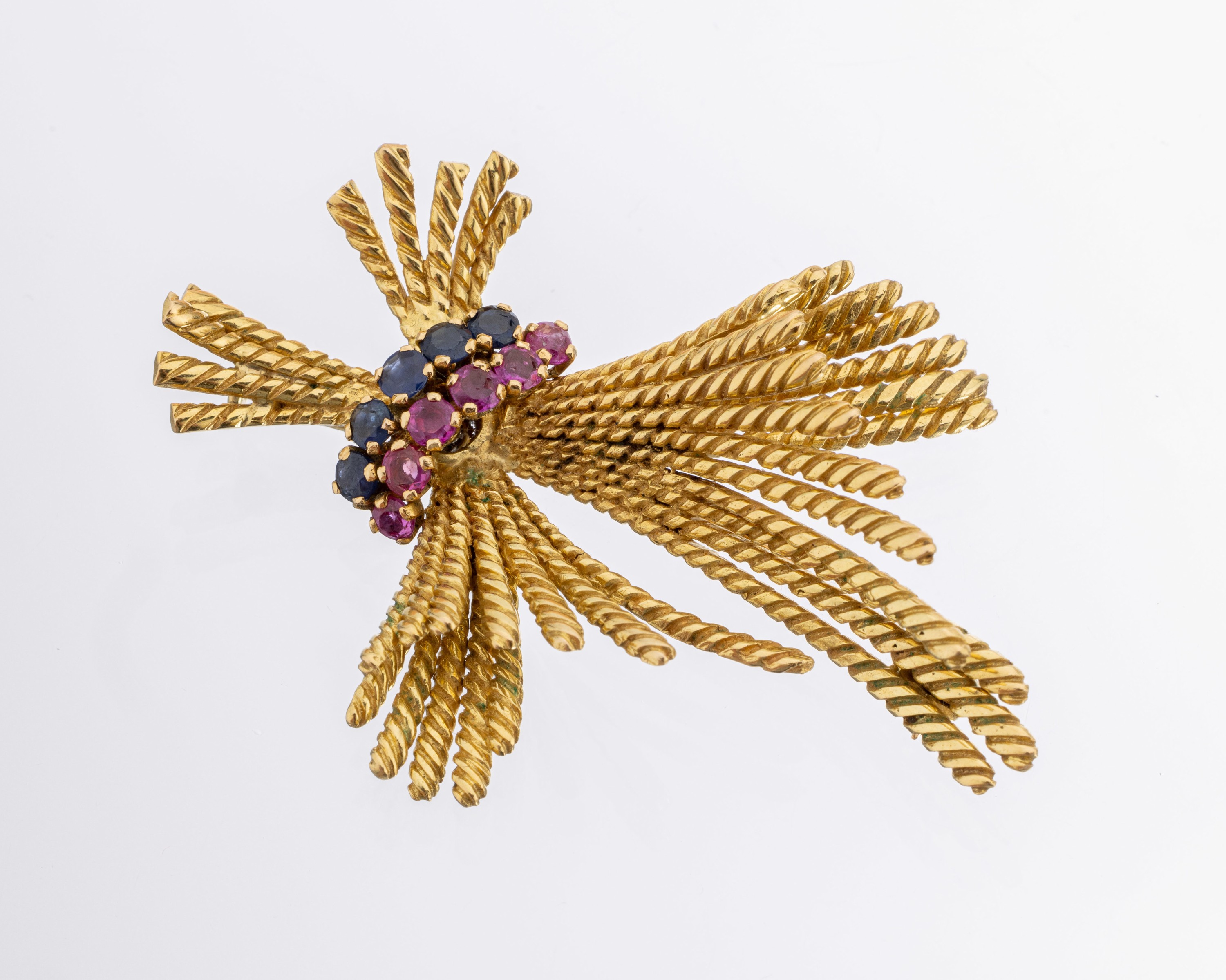18 kt Gold Farbstein-Brosche, GG 750/000, rundfacett. Rubine und Saphire, 1970er Jahre, Kordeldekor, ca. 14.8 g, L. ca. 5.5 cm