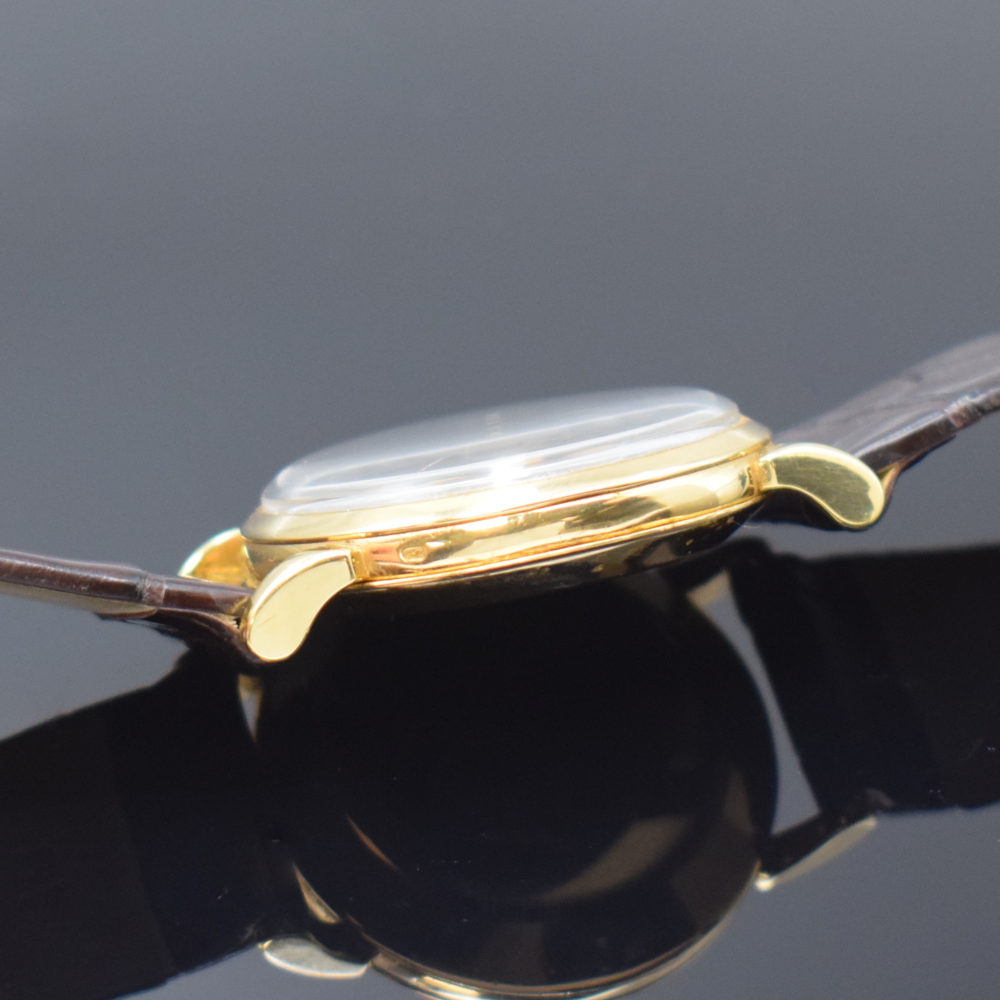 Detail e: OMEGA Herrenarmbanduhr in GG 750/000 mit Hammerautomatik Referenz 2445, Schweiz um 1947, 3-teil. Geh., Boden und Glasrand aufgedr., Lederband m. ...