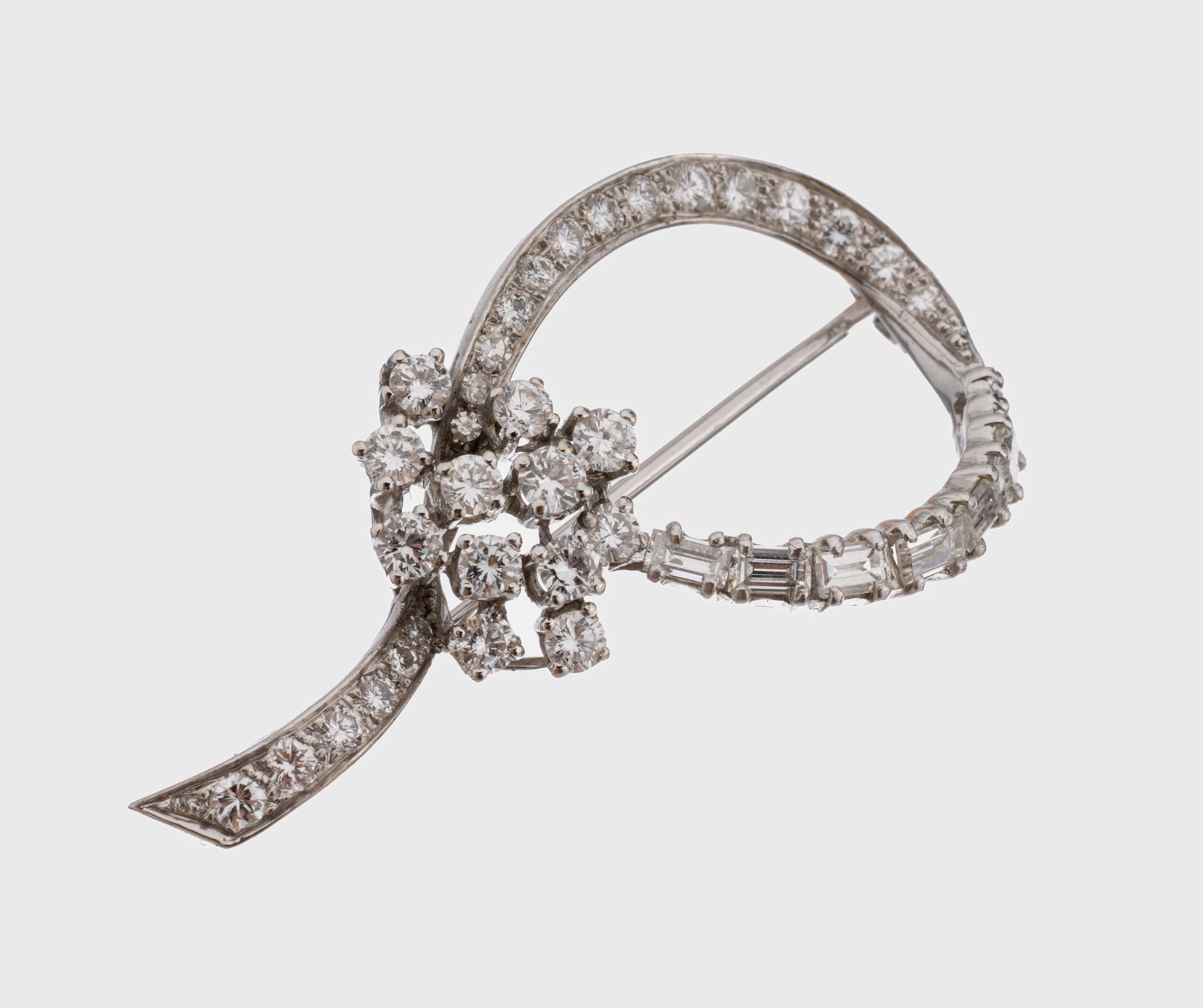 18 kt Gold Diamant-Brosche, WG 750/000, geschwungene Gestaltung, 26 Brillanten, 5 8/8 -Diamanten und 7 Diamantbaguettes zus. ca. 1.20 ct feines ...
