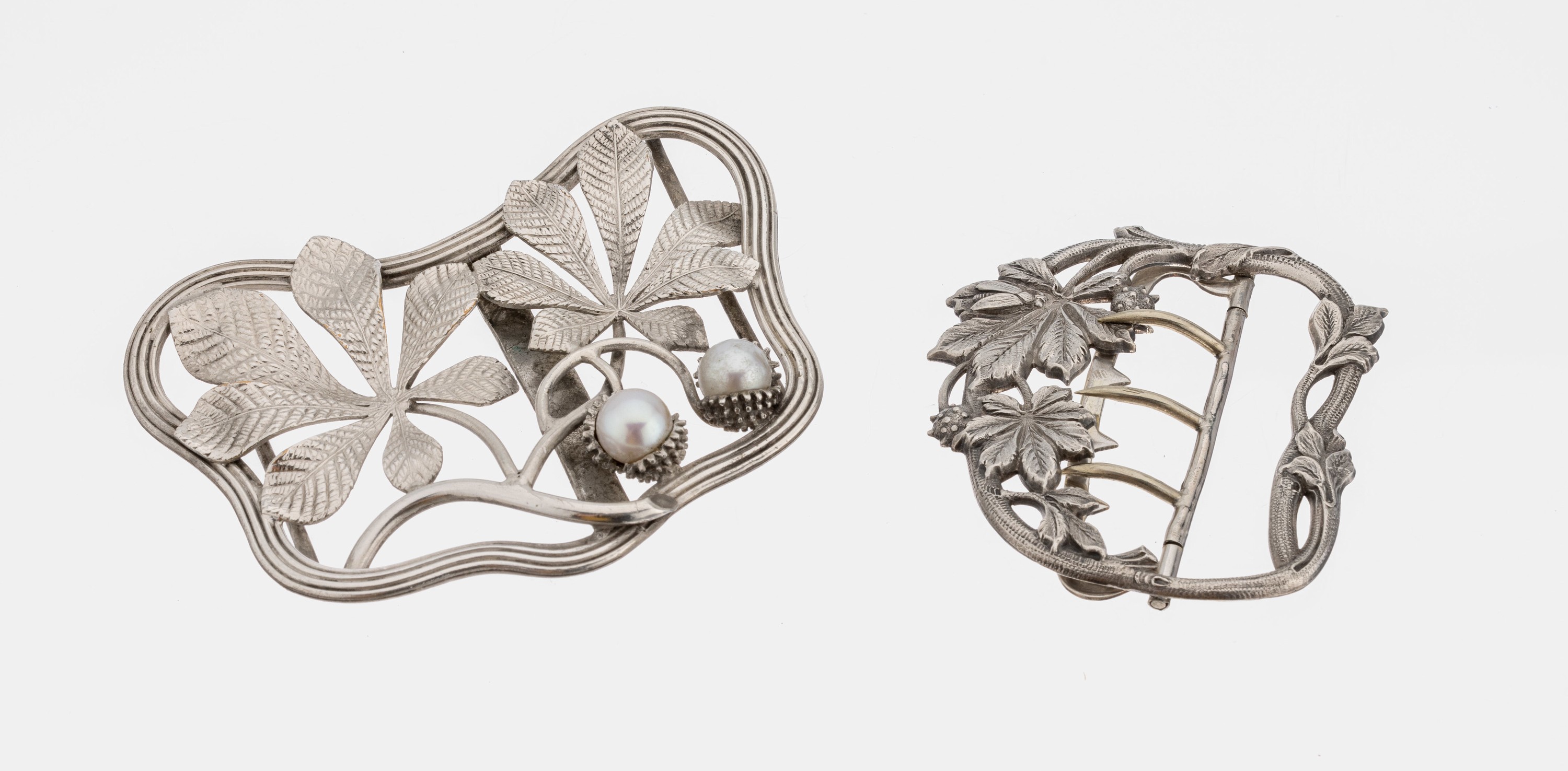 Konvolut 2 Gürtelschließen, 1 x Silber, florale Darstellung mit Insekten, ca. 6 x 5 cm, 1 x Metall versilbert, geschwungen floral,2 Kunstperlen, ...