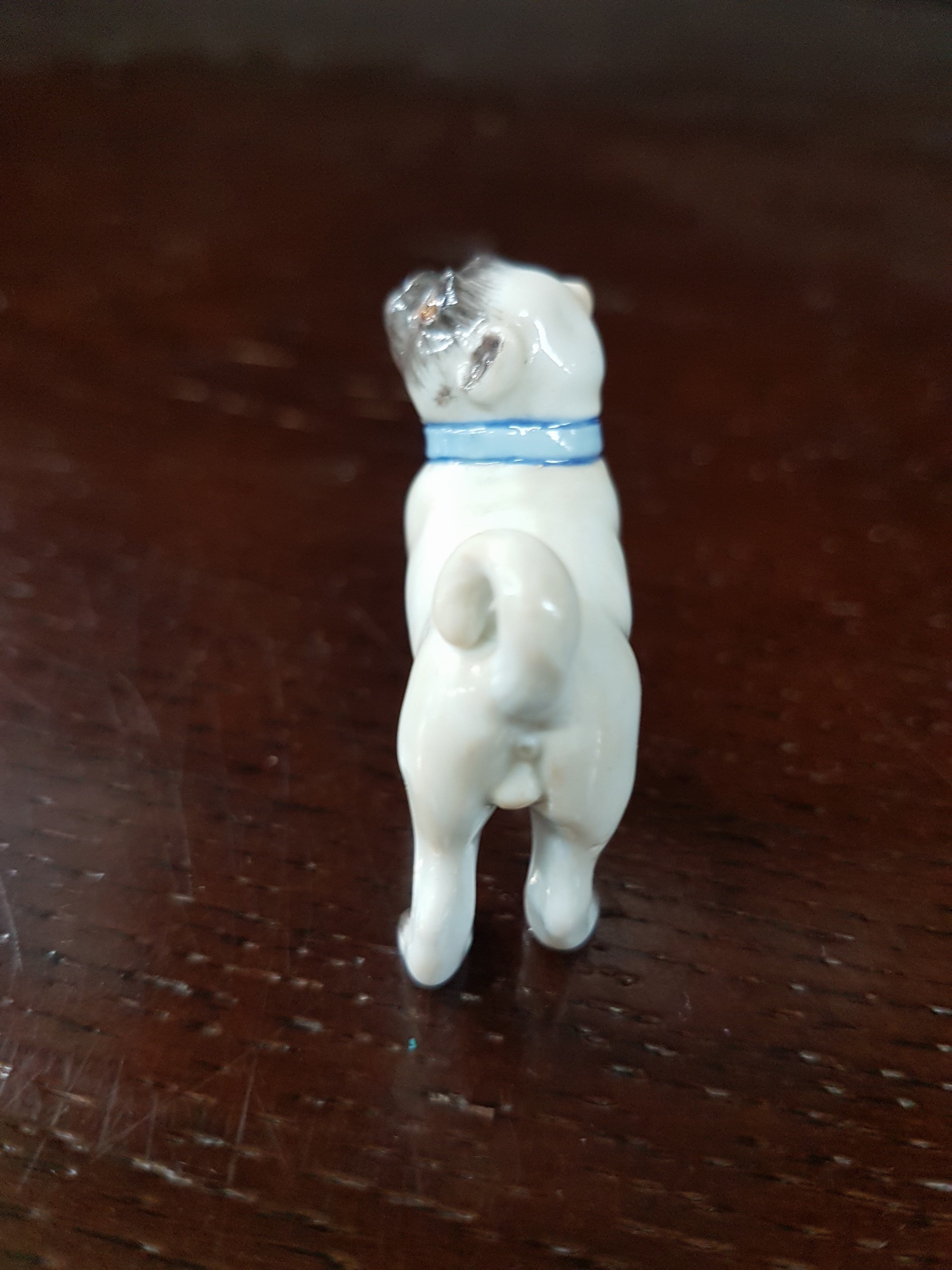 Detail b: Miniatur-Mops, Meissen, 20.Jh., Porzellan, feine farbige Bemalung, Prägenr. 644, H. 3,5 cm