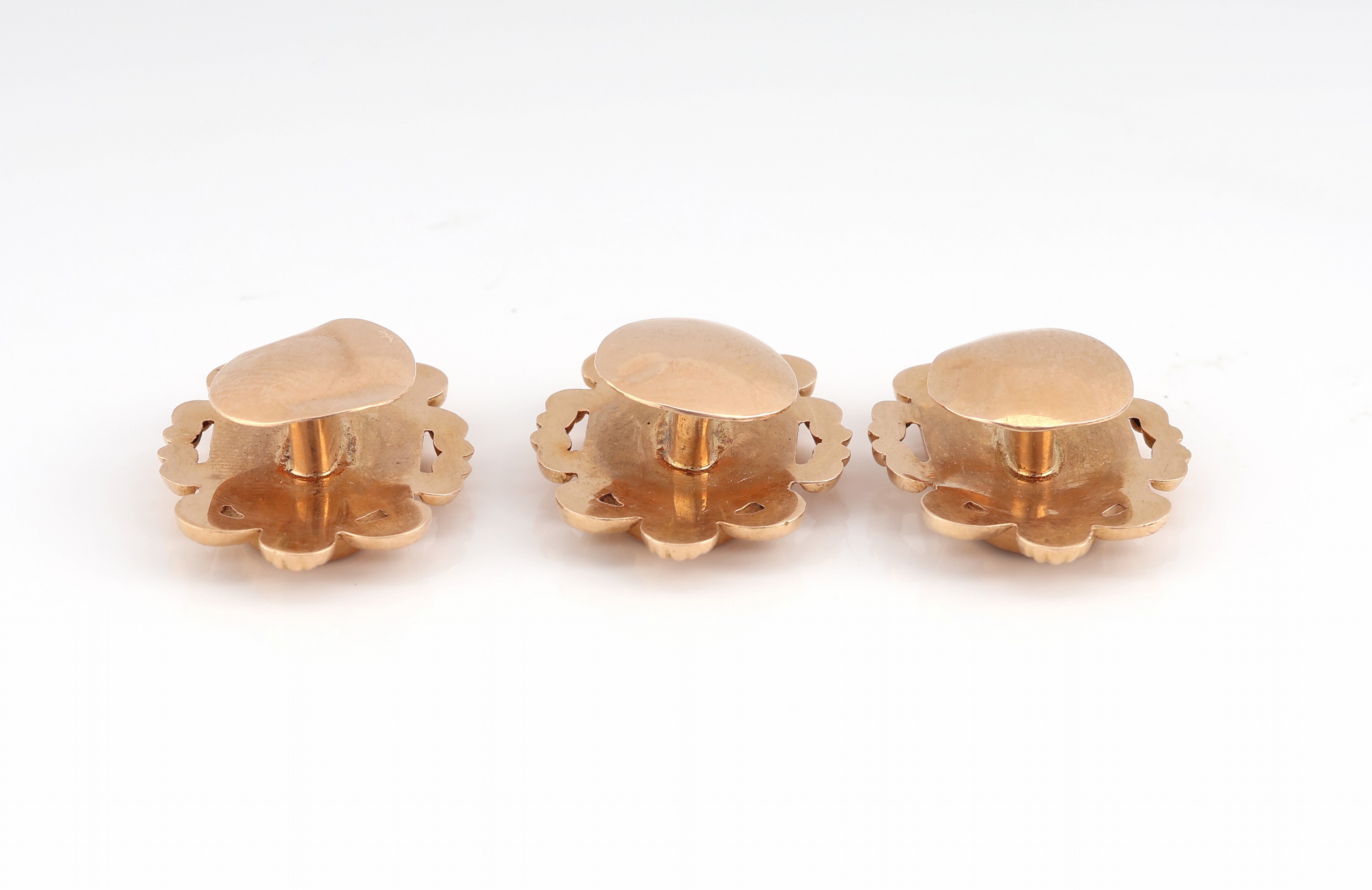 Detail c: Set 3 14 kt Gold Frackknöpfe, um 1840, GG 585/000 gepr., hohl gearbeitet, geschwungene Ornamentik mit Voluten, mittig Zierelement mitEmail in ...