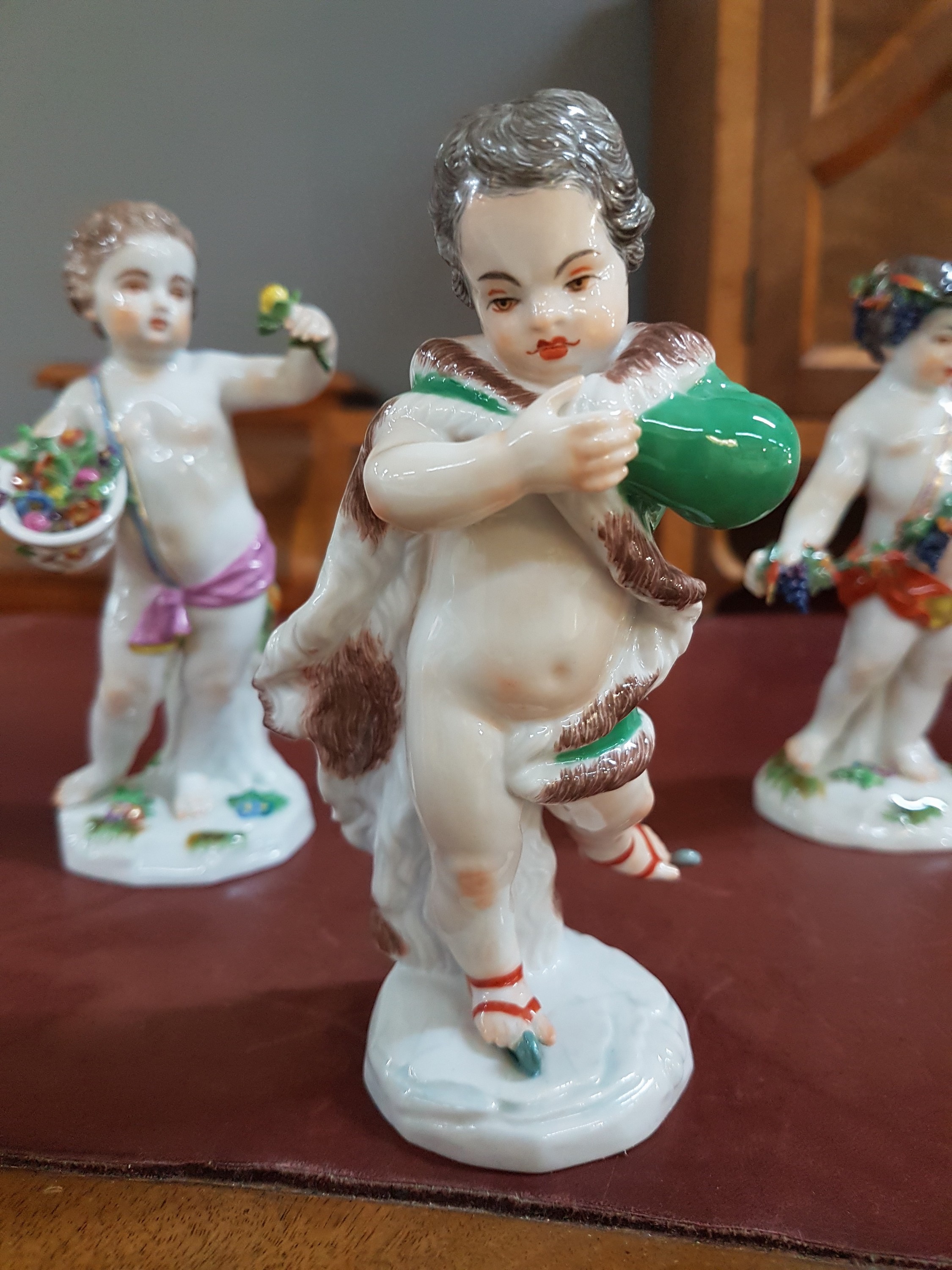 Detail b: 4 Porzellanfiguren, Meissen, 20. Jh., Allegorien auf die vier Jahreszeiten, Amoretten mit Blumen, Ähren (Sichel abgebrochen, aber vorhanden), ...