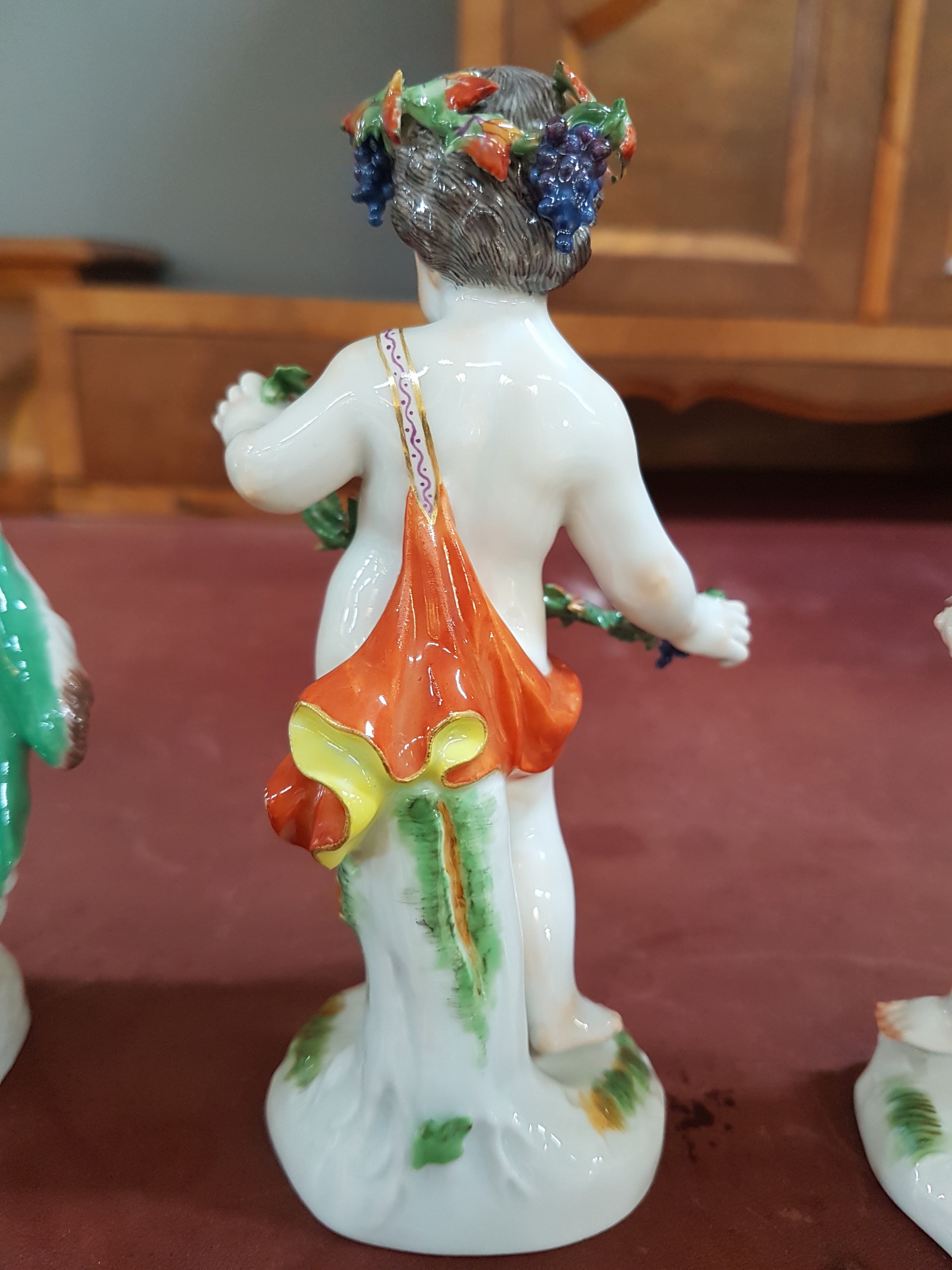 Detail g: 4 Porzellanfiguren, Meissen, 20. Jh., Allegorien auf die vier Jahreszeiten, Amoretten mit Blumen, Ähren (Sichel abgebrochen, aber vorhanden), ...