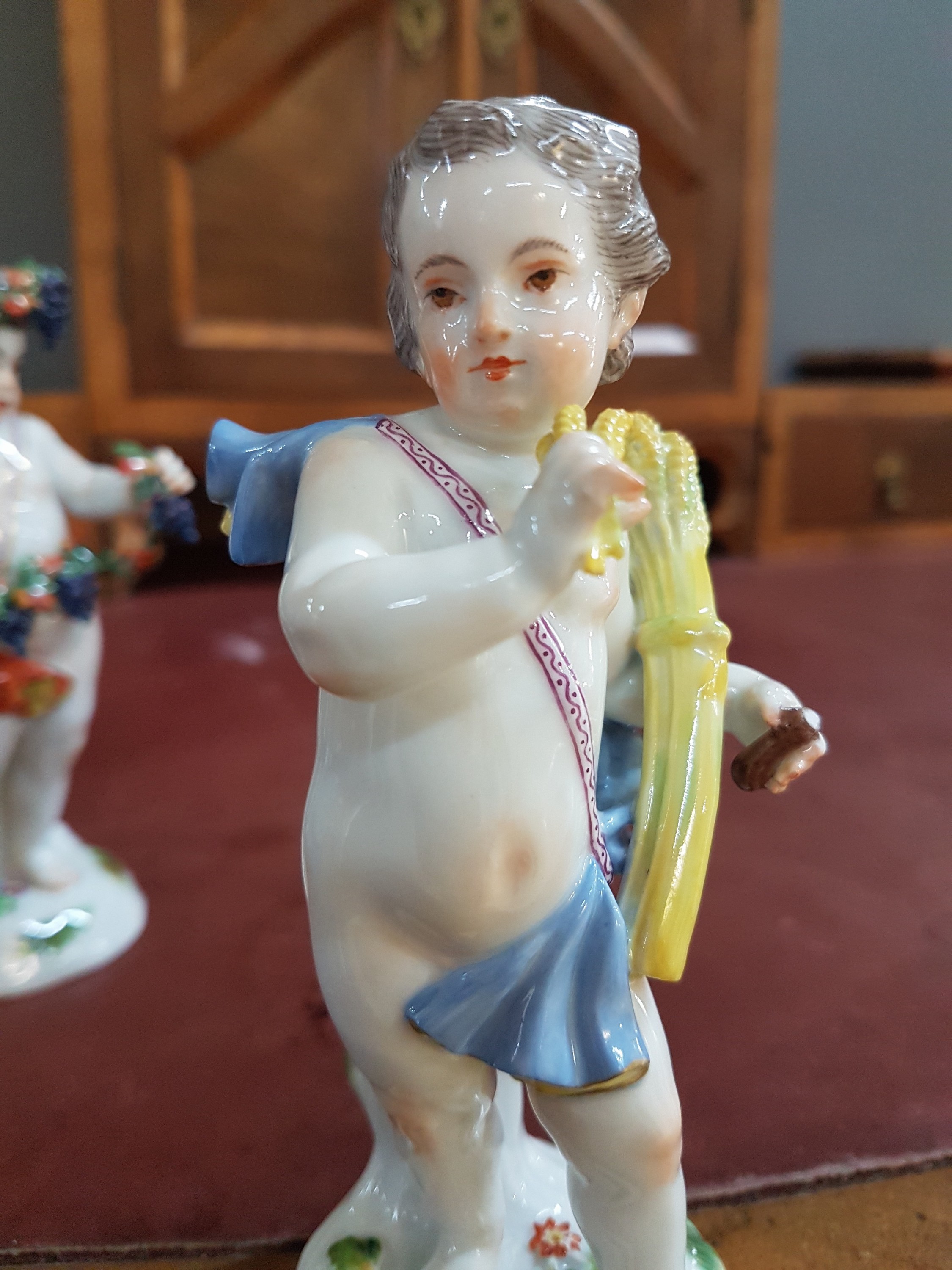 Detail l: 4 Porzellanfiguren, Meissen, 20. Jh., Allegorien auf die vier Jahreszeiten, Amoretten mit Blumen, Ähren (Sichel abgebrochen, aber vorhanden), ...