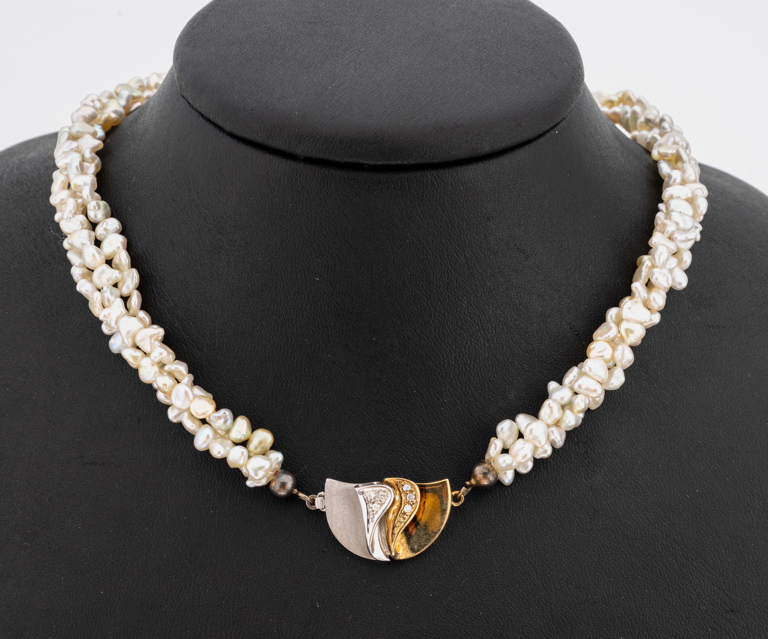 Zuchtperl-Collier mit 14 kt Gold Brillant- Schmuckschließe, GG/WG 585/000, 3-rhg. ineinander geflochtene Stränge, unrunde Süßwasserzuchtperlen, ...