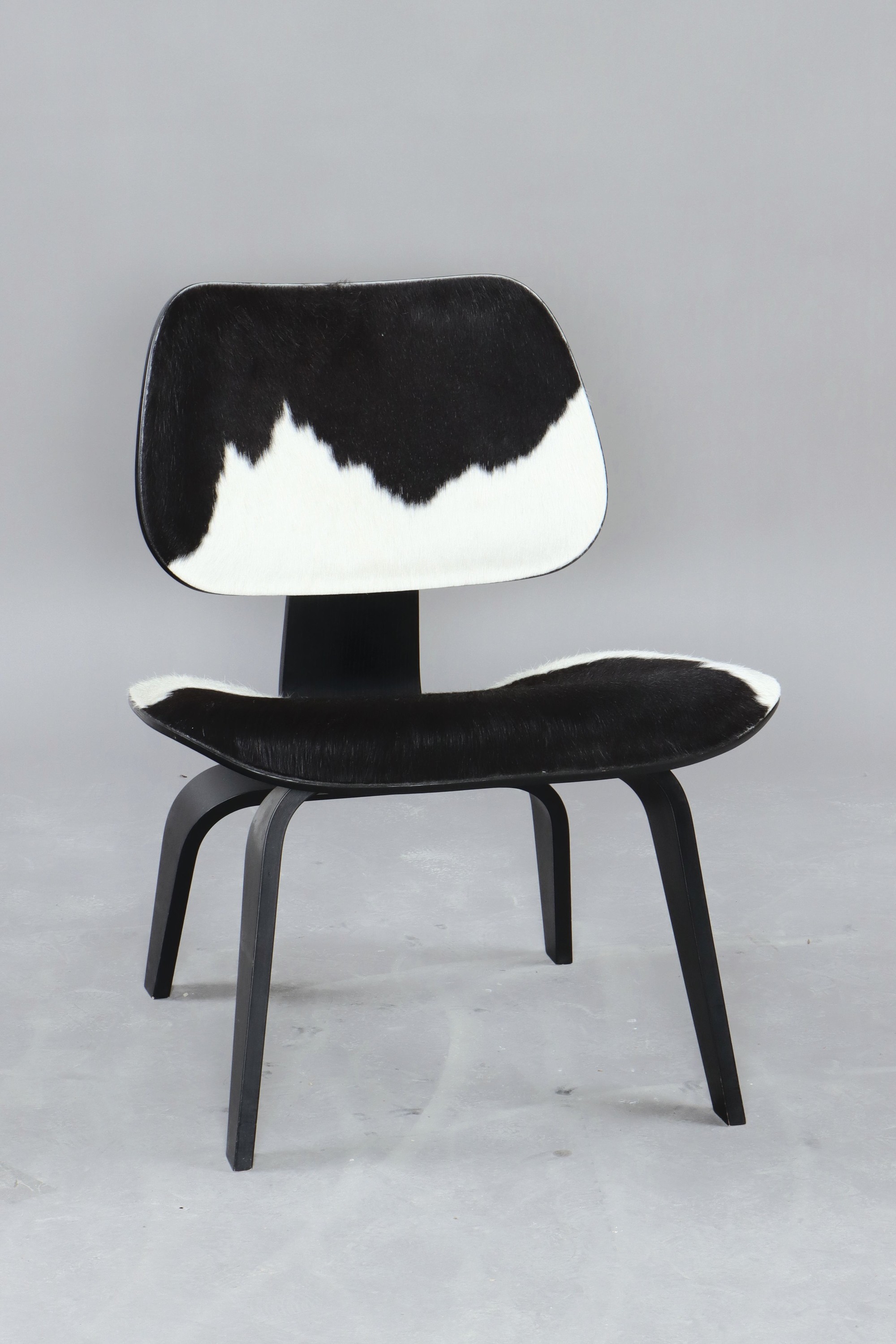 Lounge Chair Wood, von Charles Eames, Entwurf 1945, Design Vitra, Schichtholz schwarz lackiert, Kuhfellbezug, Herstelleretikett unter dem Sitz diese ...