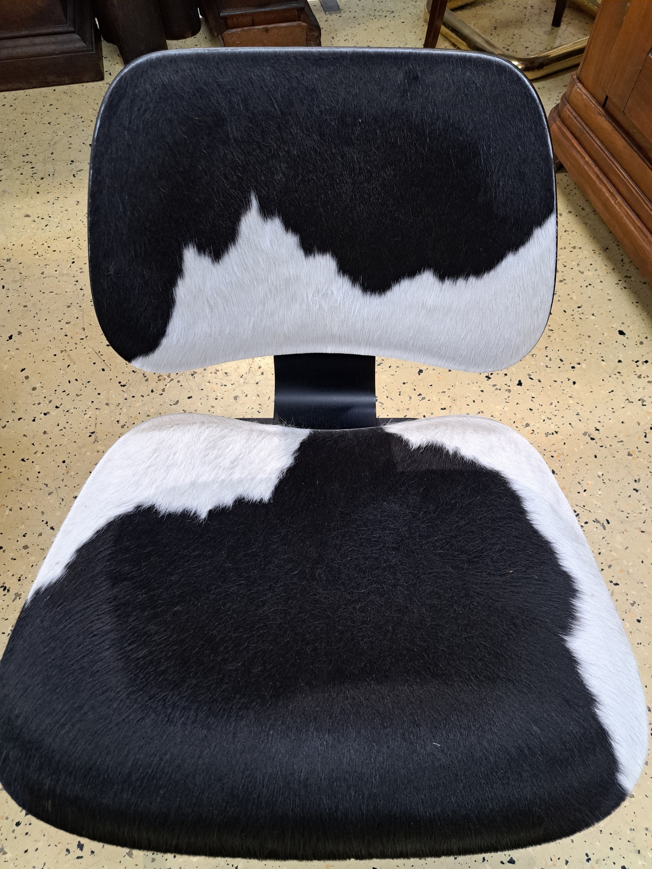 Detail a: Lounge Chair Wood, von Charles Eames, Entwurf 1945, Design Vitra, Schichtholz schwarz lackiert, Kuhfellbezug, Herstelleretikett unter dem Sitz diese ...