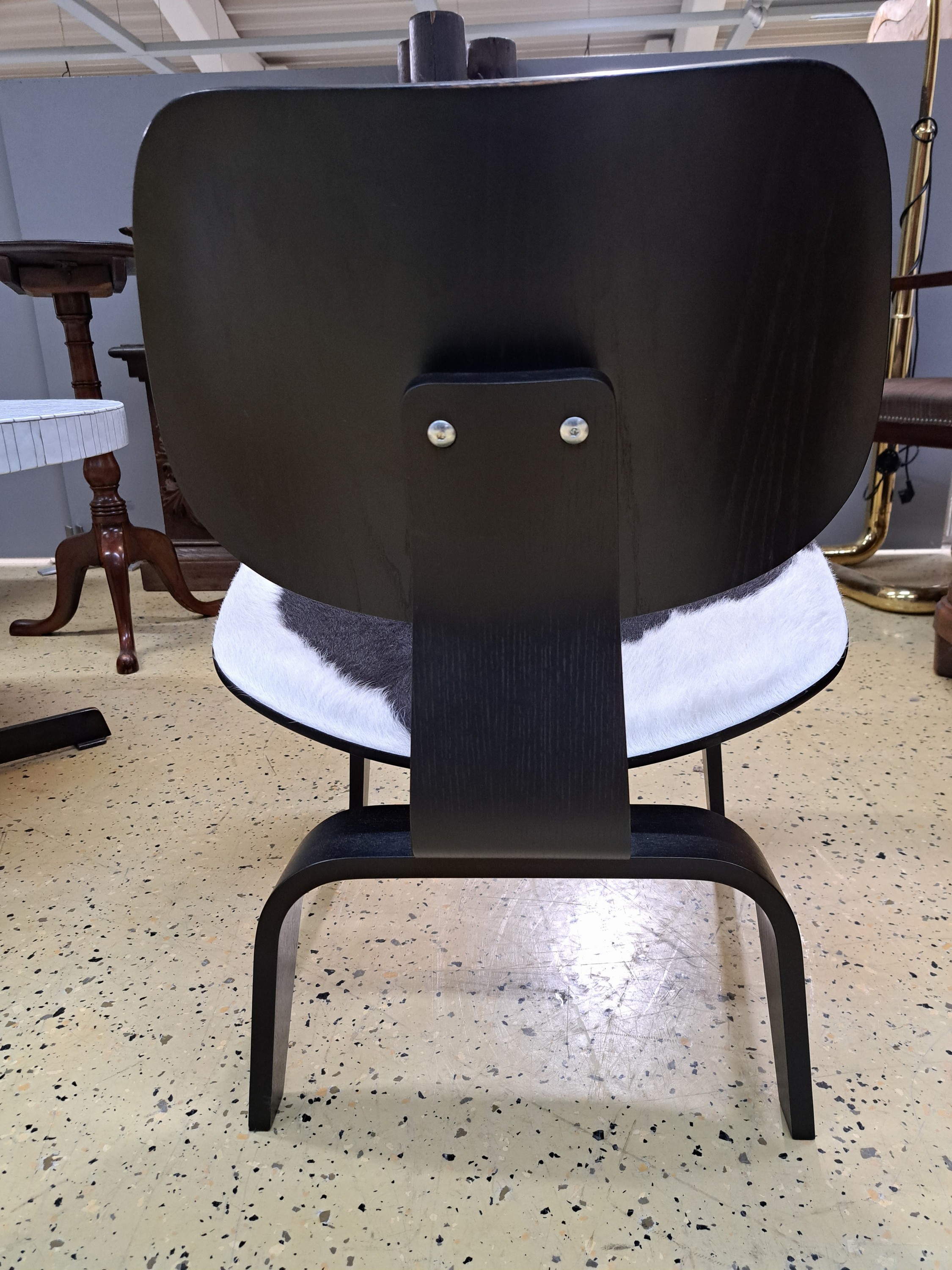 Detail b: Lounge Chair Wood, von Charles Eames, Entwurf 1945, Design Vitra, Schichtholz schwarz lackiert, Kuhfellbezug, Herstelleretikett unter dem Sitz diese ...
