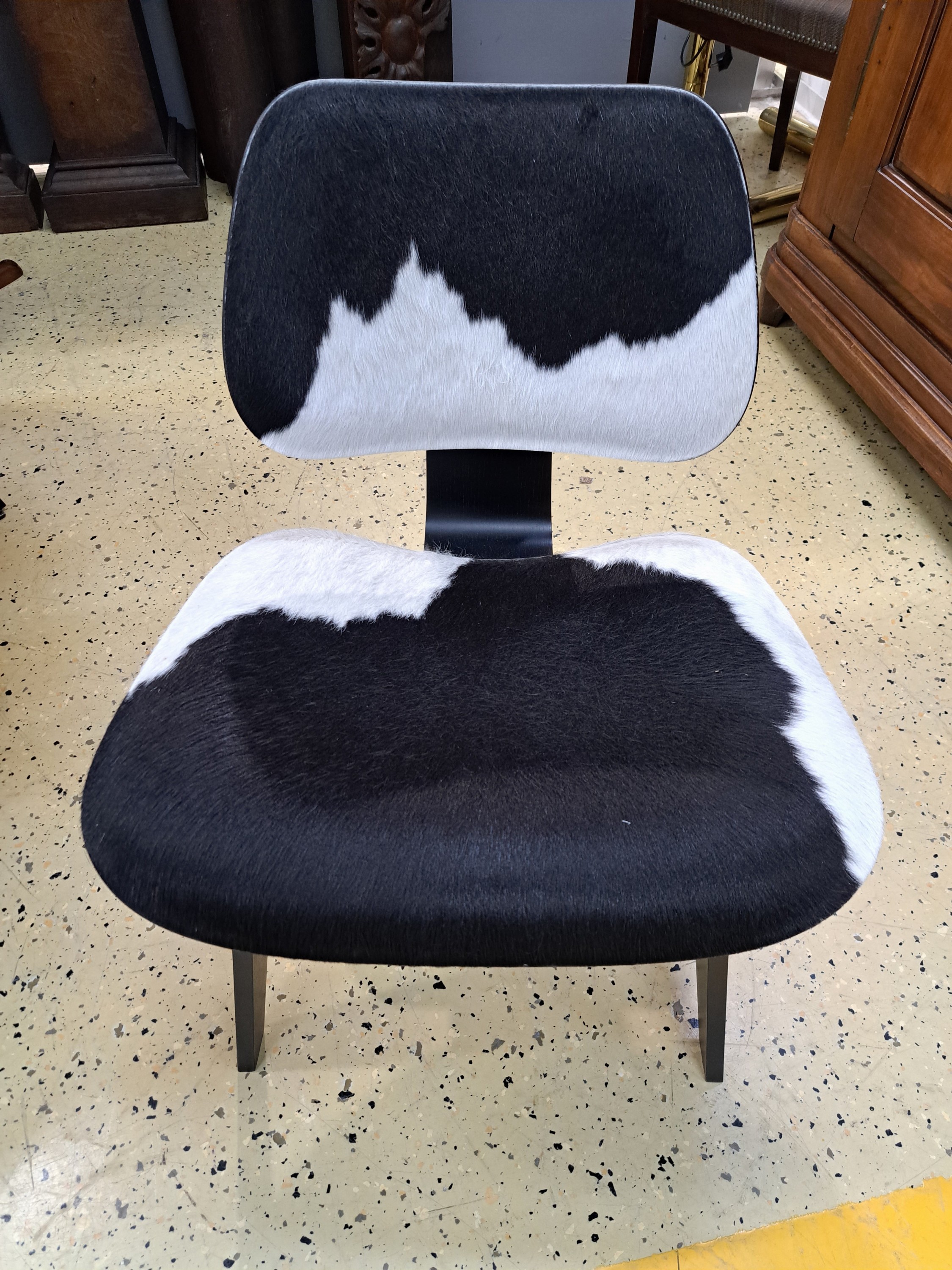 Detail d: Lounge Chair Wood, von Charles Eames, Entwurf 1945, Design Vitra, Schichtholz schwarz lackiert, Kuhfellbezug, Herstelleretikett unter dem Sitz diese ...